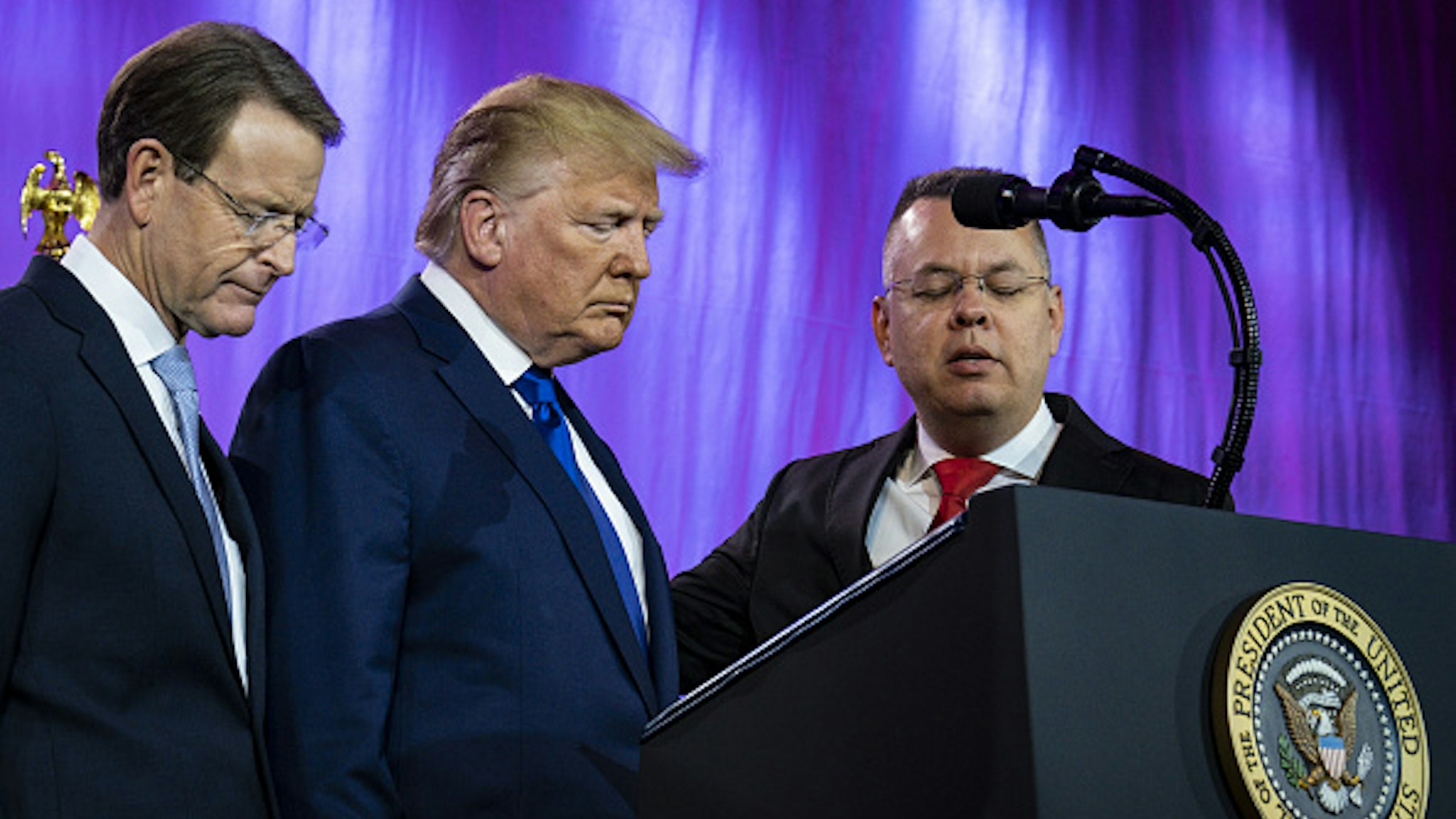 U.S. President Donald Trump, center, prays with Tony Perkins, president of the Family Research Council, left, and Pastor Andrew Brunson at the Values Voter Summit at the Omni Shoreham Hotel in Washington, D.C., U.S., on Saturday, Oct. 12, 2019. Trump is the target of an impeachment inquiry on Capitol Hill, evangelical Christians who gathered across town were unfazed by his request of Ukraine to investigate political rival Joe Biden.