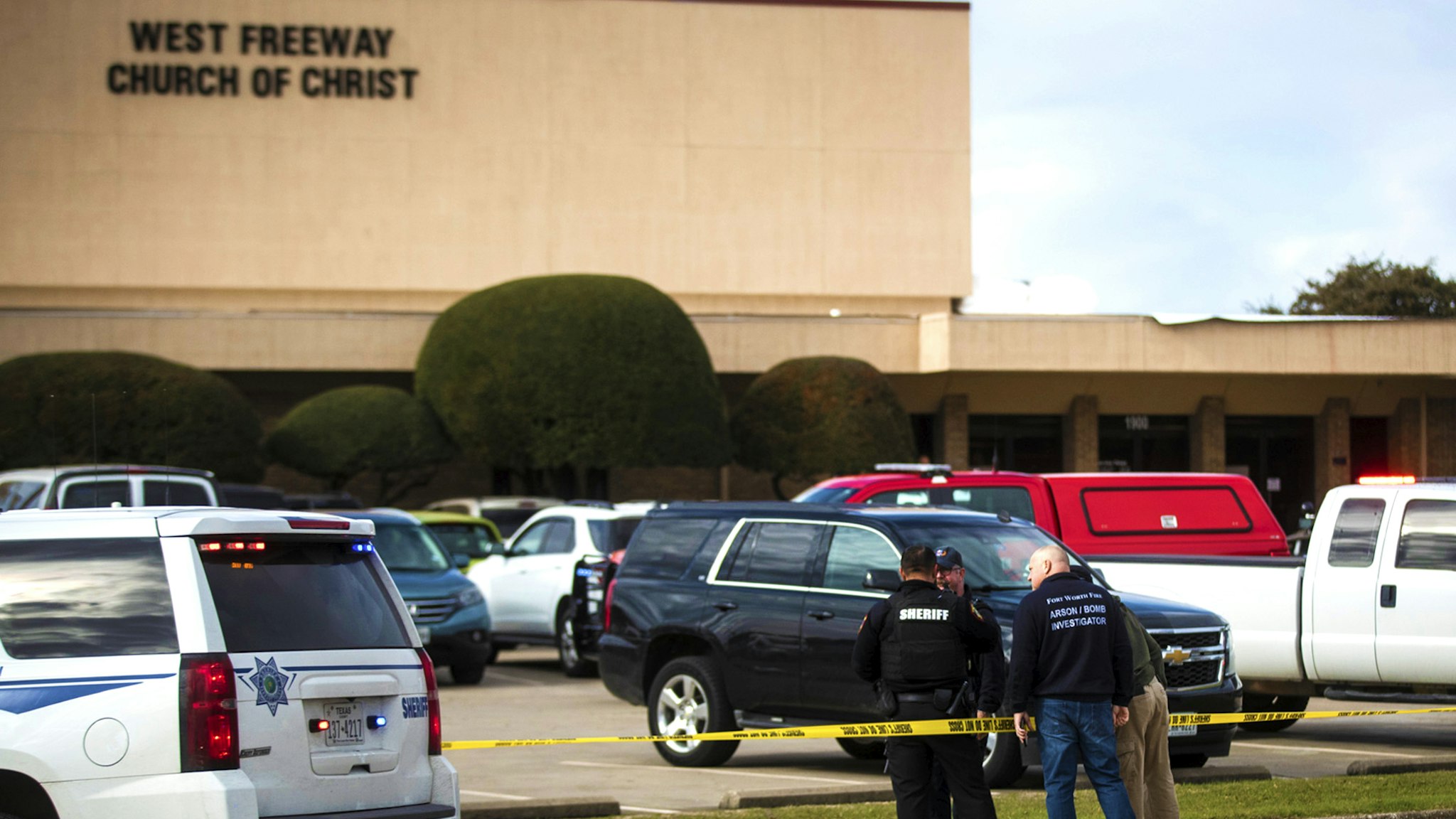 Police and fire department officials surround a scene of a shooting Sunday, Dec. 29, 2019, at West Freeway Church of Christ in White Settlement, Texas.