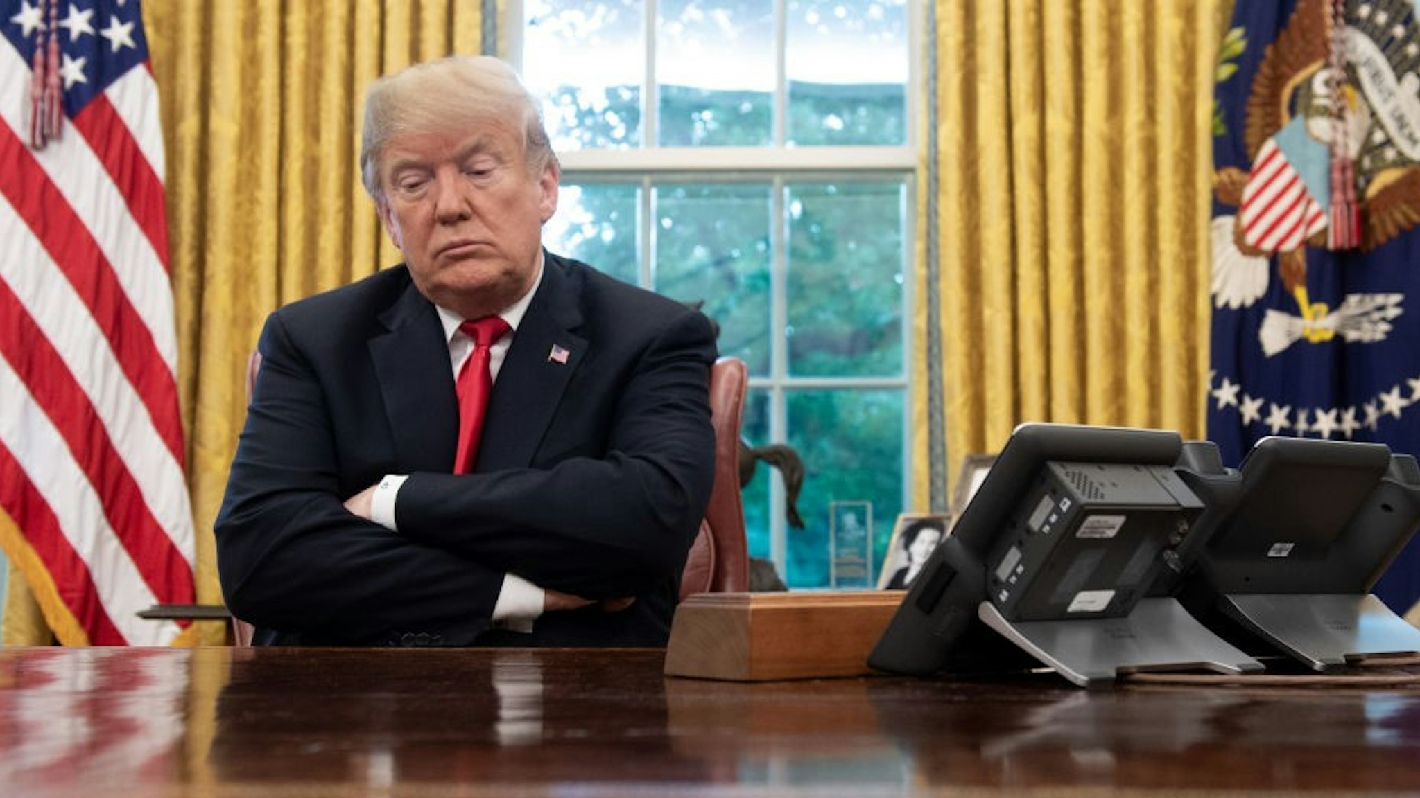 US President Donald Trump sits at the Resolute Desk during a briefing on Hurricane Michael in the Oval Office of the White House in Washington, DC, October 10, 2018.