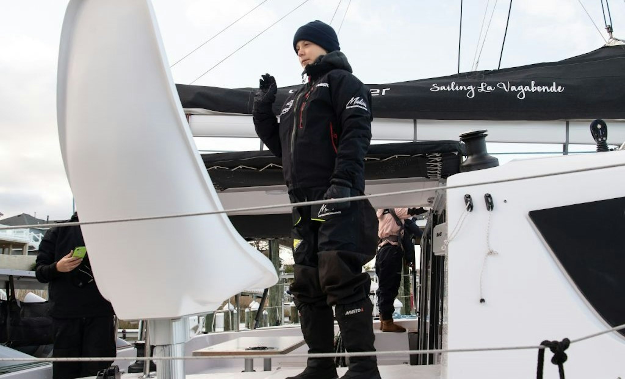 Swedish climate activist Greta Thunberg waves from aboard the catamaran La Vagabonde as she sets sail to Europe in Hampton, Virginia, on November 13, 2019. - "Extremely educational" is how Greta Thunberg sums up her North American sojourn as she prepares to cross the Atlantic once more, this time bound back for Europe. The 16-year-old Swede, who became world famous for founding the "school strikes for the climate," will set sail Wednesday morning, weather permitting, after 11 hectic weeks of criss-crossing the US and Canada, making headlines at every turn.
