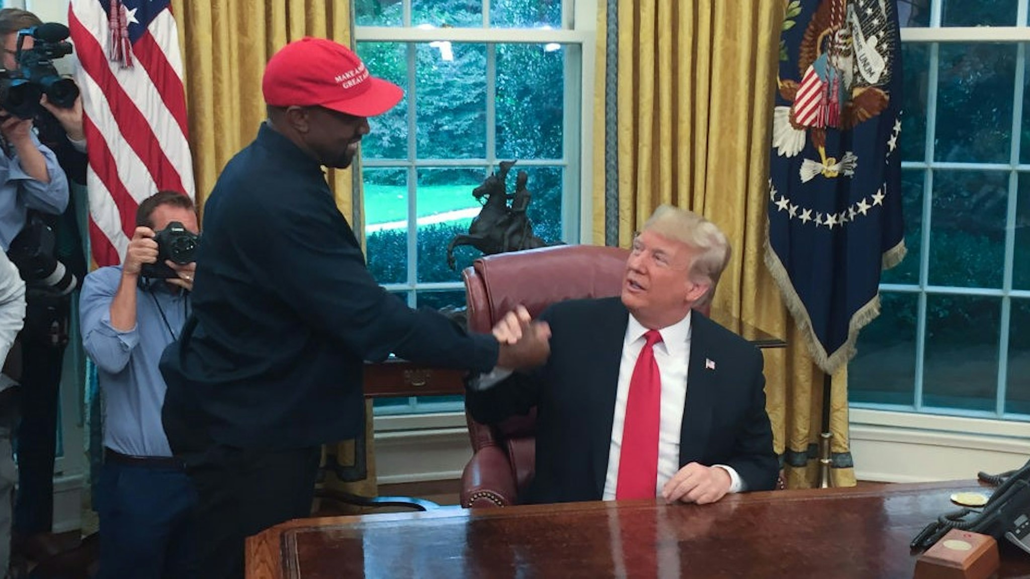(Files) in this file photo US President Donald Trump meets with rapper Kanye West in the Oval Office of the White House in Washington, DC, October 11, 2018. - Rapper Kanye West, who has been outspoken in his support for President Donald Trump, now says he's going to focus on his music and fashion after being "used" in the world of politics, October 30, 2018.