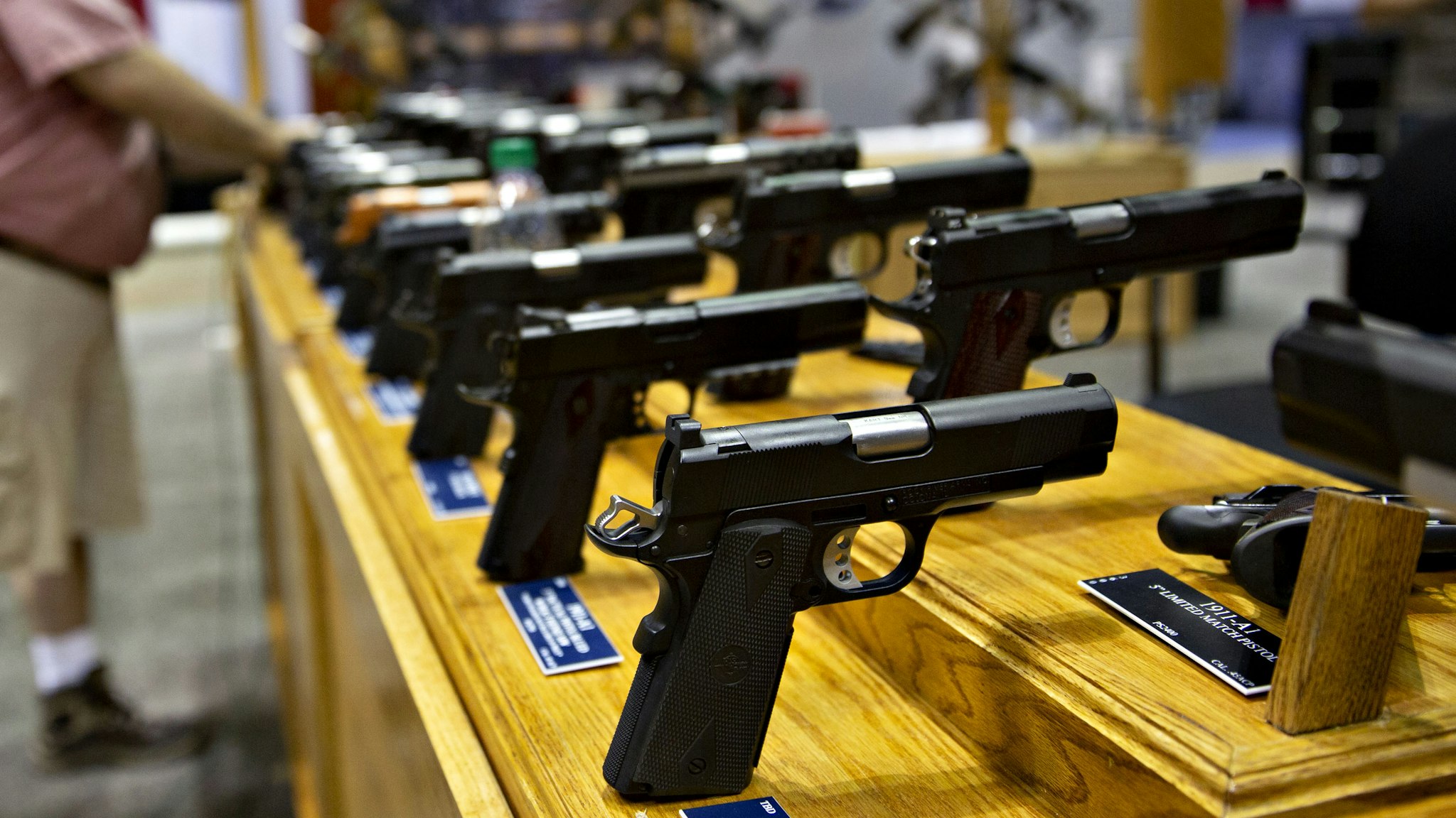 A worker sets up a display of handguns on the floor of the exhibition hall ahead of the National Rifle Association (NRA) annual meeting at the Indiana Convention Center in Indianapolis, Indiana, U.S., on Thursday, April 25, 2019. President Donald Trump will speak at the NRA Institute for Legislative Action (NRA-ILA) Leadership Forum on Friday.
