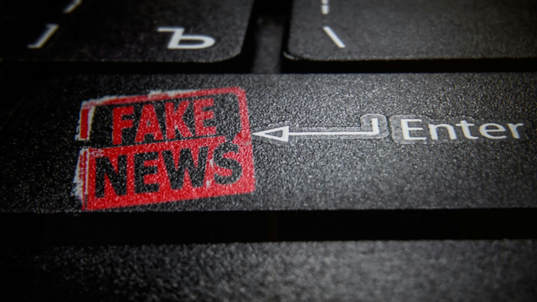 In this photo illustration a fake news logo and a laptop keyboard.