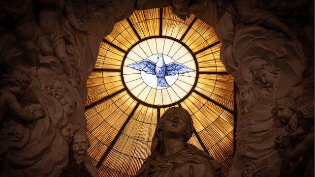 A stained glass window depicting a the Christian symbol of a white dove in the Cathedral of Naples, or Duomo di Napoli, in the Campania region of Italy on 29 December 2019.