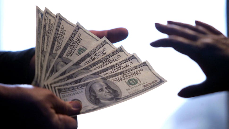 Cash. United States Dollar notes exchange hands at a local bank in Beijing 15 May 2006.