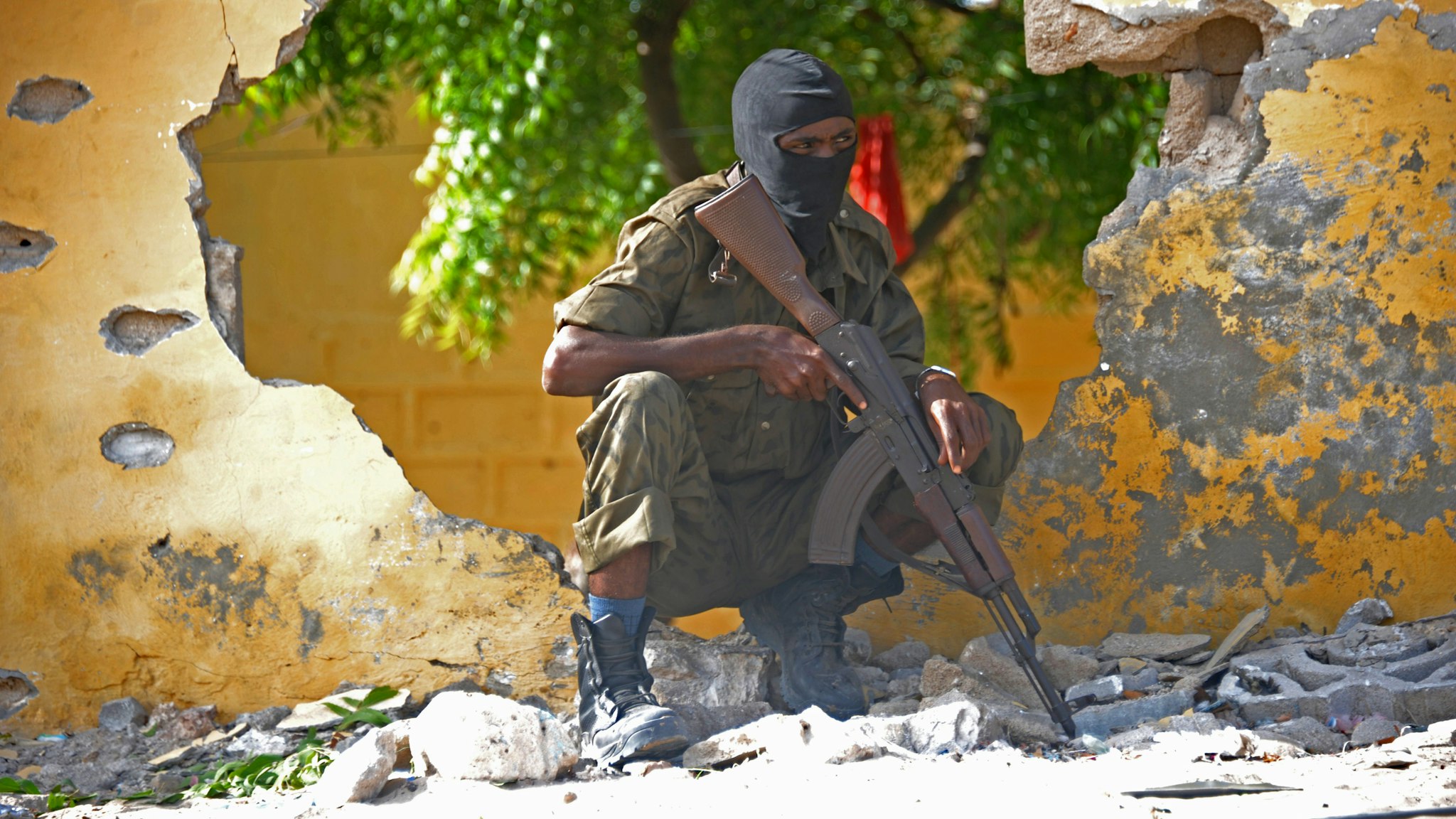 A Somali soldier stands guard next to the site where Al Shebab militants carried out a suicide attack against a military intelligence base in Mogadishu on June 21, 2015. Shebab militants launched a major suicide raid on June 21 against a military intelligence base in the capital Mogadishu, setting off a car bomb before storming inside, security officials said. Somalia's interior ministry said the three attackers were all killed in the raid, and that Somali security forces who fought them suffered no casualties.