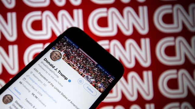 Donald Trump's Twitter profile is seen on a smartphone against a backdrop with the CNN logo, in Ankara, Turkey on December 9, 2018. (Photo by Ali Balkci/Anadolu Agency/Getty Images)