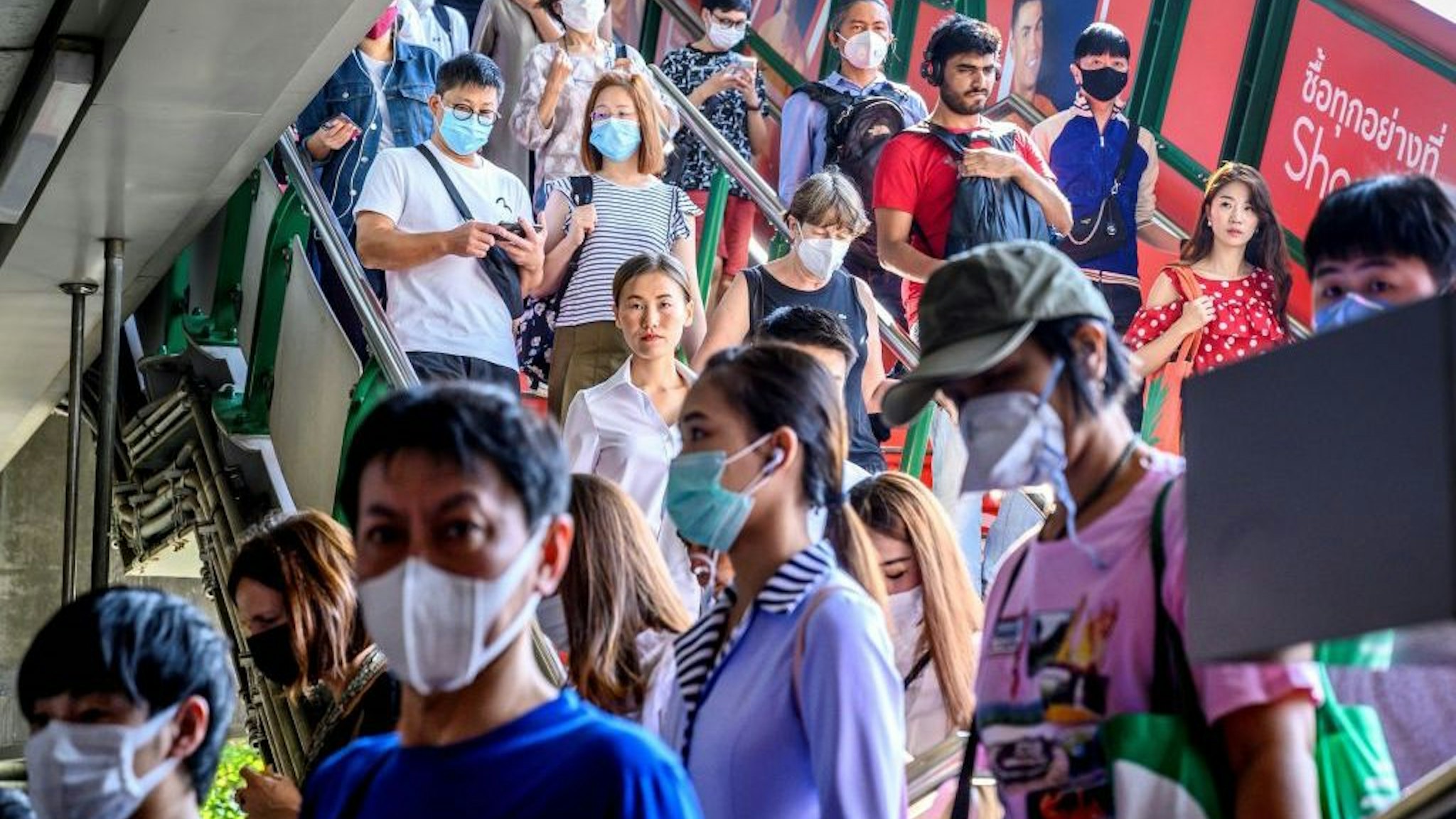 People with face masks arrive at a BTS Sky train station in Bangkok on January 27, 2020. - Thailand has detected eight Coronavirus cases so far -- three of whom are receiving treatment in hospital and five of whom have been discharged, according to a statement from Health Minister Anutin Charnvirakul. (Photo by Mladen ANTONOV / AFP) (Photo by MLADEN ANTONOV/AFP via Getty Images)