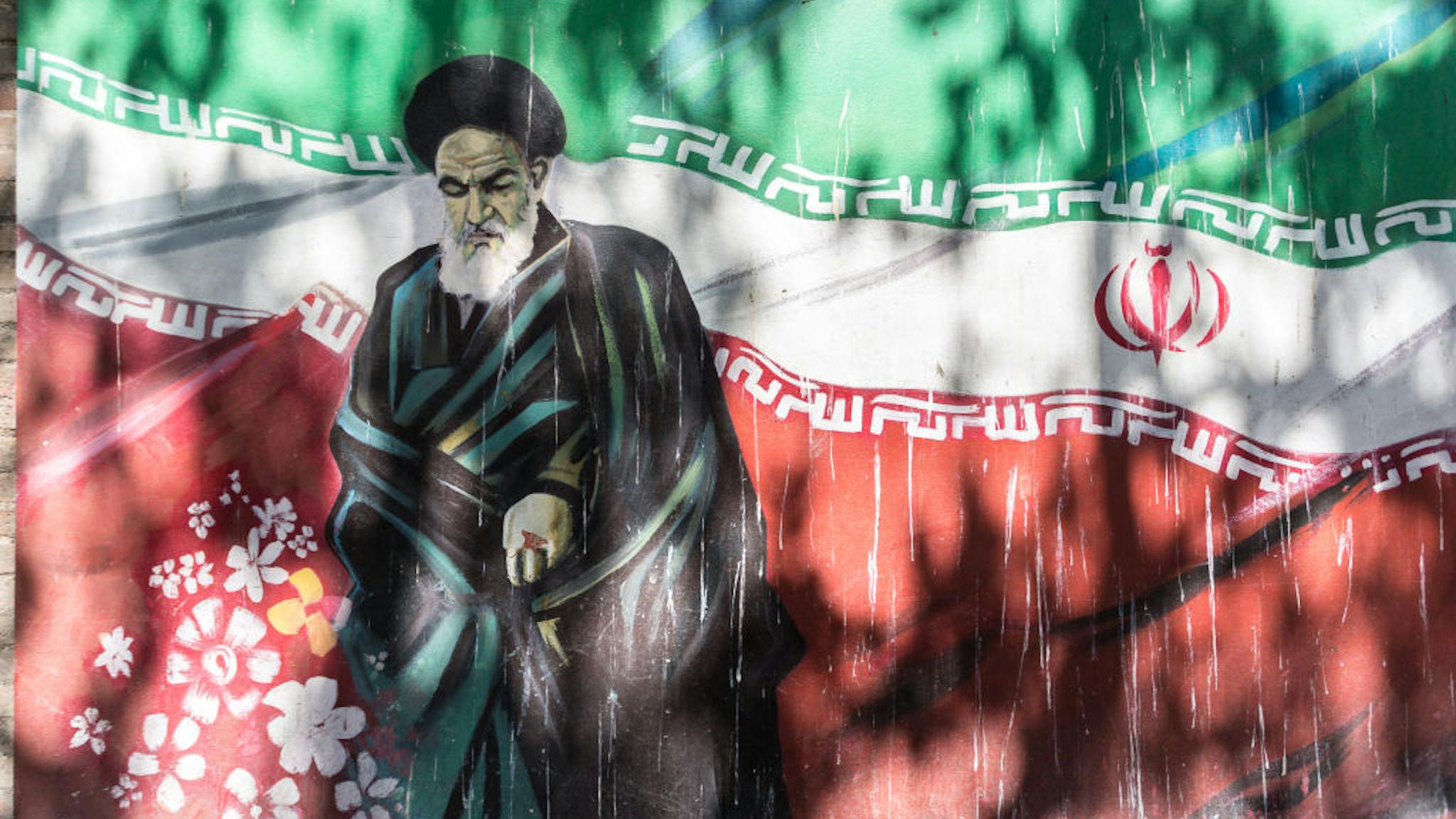 ayatollah Iran street art Revolutionary graffiti of Ruhollah Khomeini, the first post revolution Ayatollah with Iranian flag as a background on Taleqani Street in Tehran, the capital of Islamic Republic of Iran on September 27, 2018.