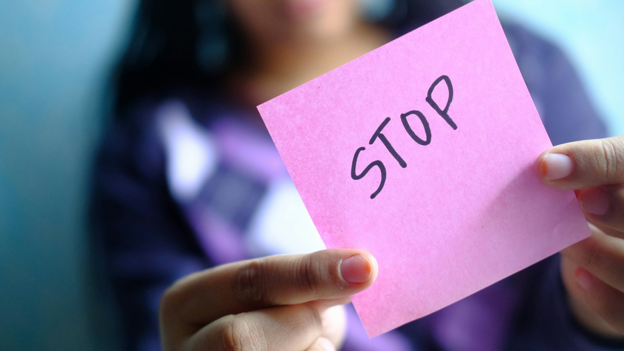 a young girl holding note pad with abuse text written