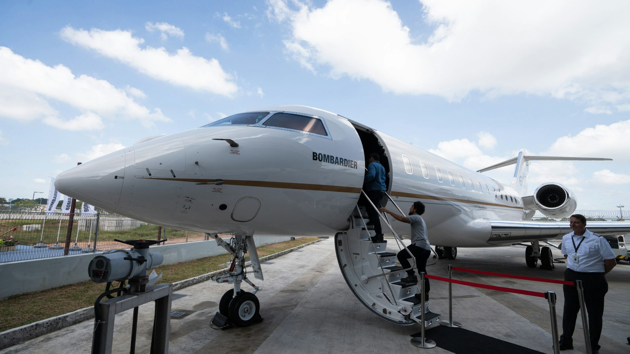 Attendees climb the airstair to a Bombardier Inc. Global 6000 business jet on display during a media event at Seletar Aerospace Heights in Singapore, on Wednesday, Feb. 27, 2019. Bombardier is more than doubling the size of its bond buybacks to as much as $1.83 billion after raising twice the amount initially expected in its new debt sale on Thursday amid a red-hot junk-bond market. Photographer: Nicky Loh/Bloomberg via Getty Images