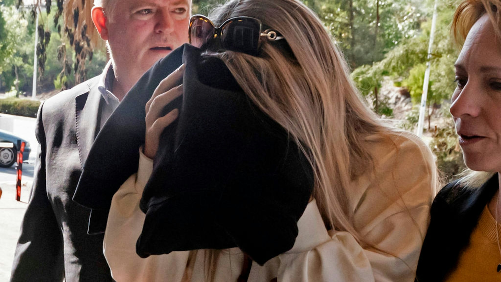 A British teenager who accused seven Israelis of gang rape covers her face as she comes in the Larnaca District Court on November 01, 2019.