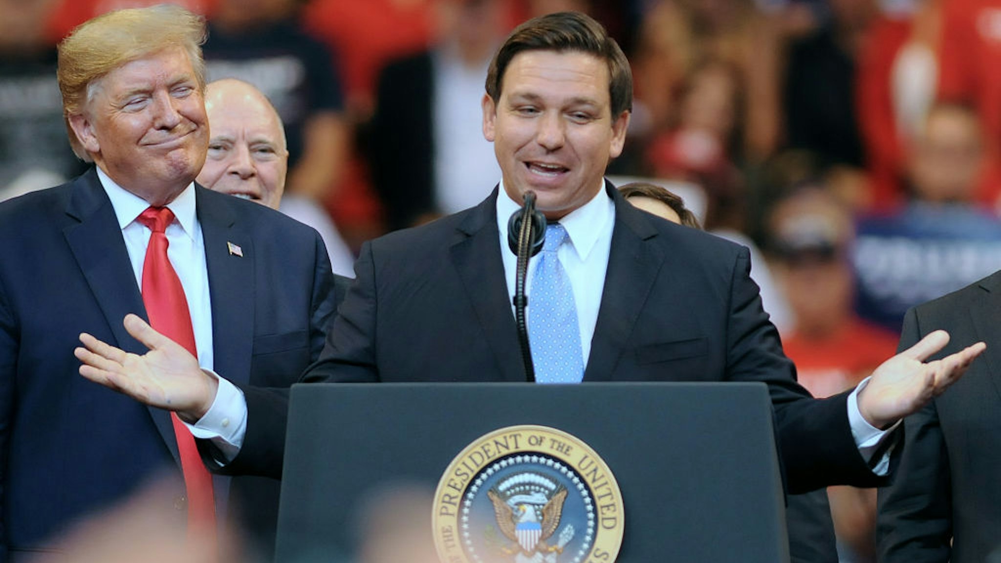President Donald Trump looks on as Florida Governor Ron DeSantis speaks during the Florida Homecoming rally at the BB&amp;T Center.