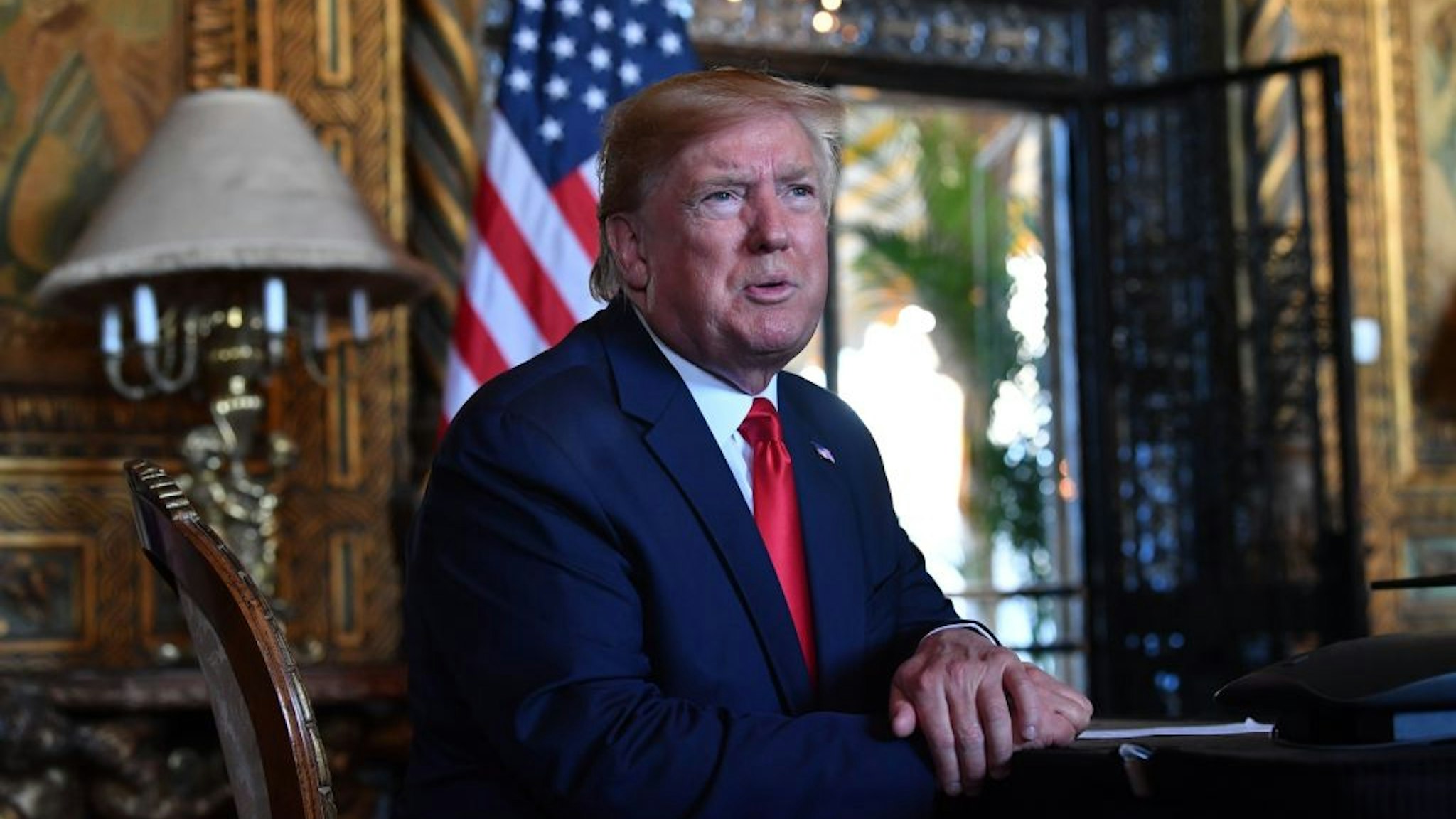 US President Donald Trump answers questions from reporters after making a video call to the troops stationed worldwide at the Mar-a-Lago estate in Palm Beach Florida, on December 24, 2019.