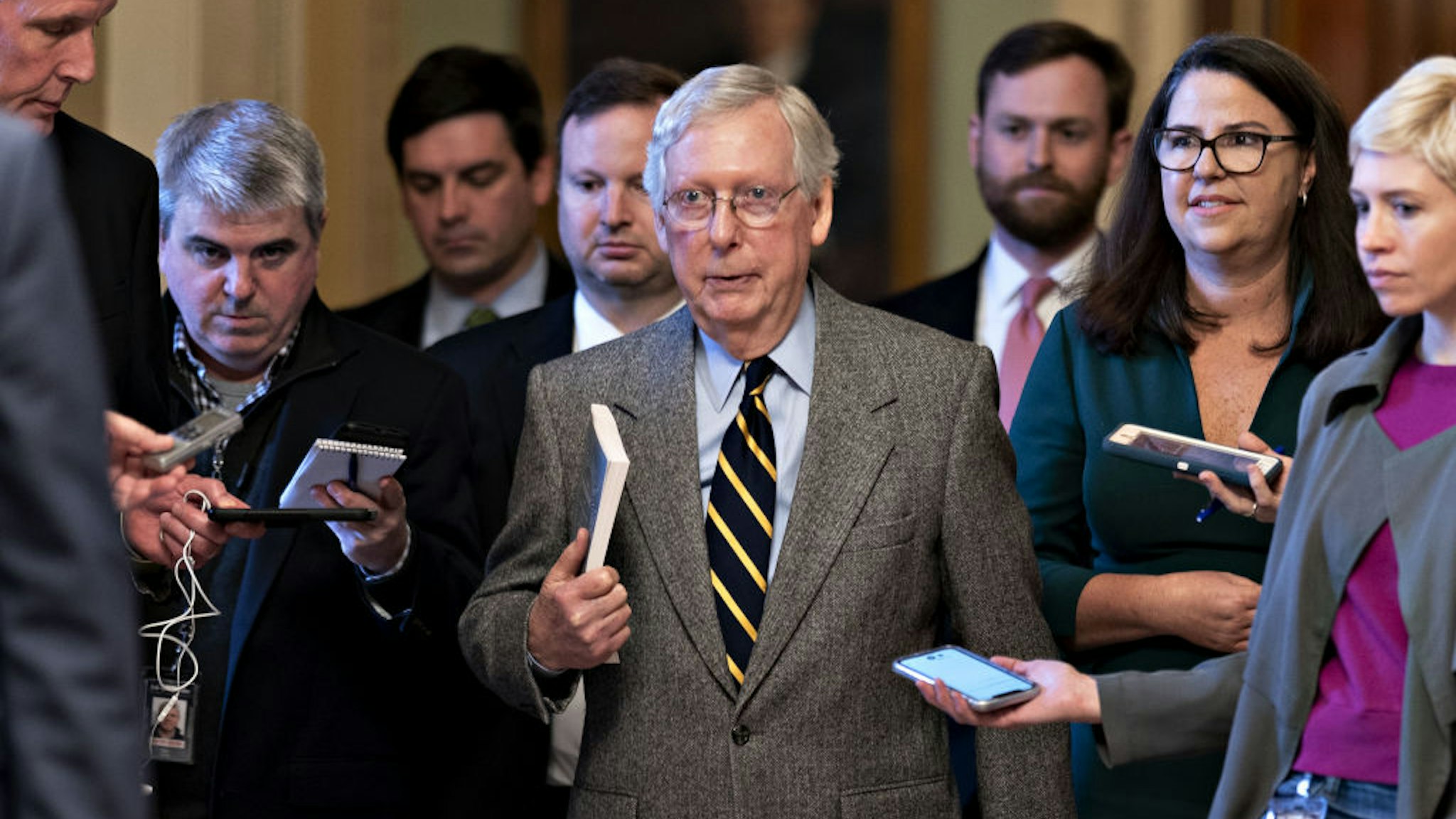 Senate Majority Leader Mitch McConnell, a Republican from Kentucky, center, walks to his office after speaking on the Senate floor at the U.S. Capitol in Washington, D.C., U.S., on Friday, Jan. 3, 2020. McConnell and House Speaker Nancy Pelosi are locked in a stare-down over the terms of President Donald Trump's impeachment trial, which carries political risks for both sides if it continues deeper into January.