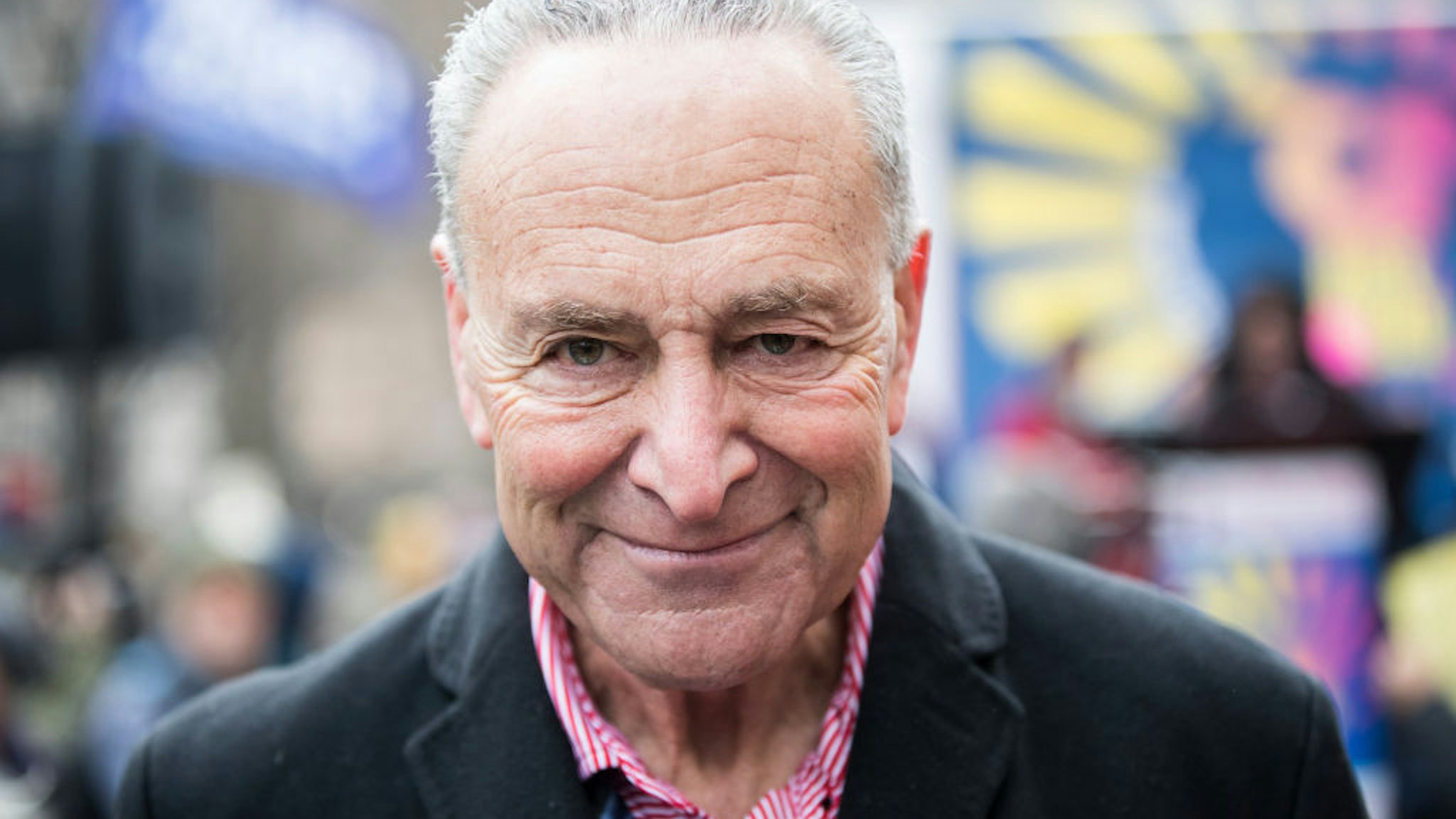 United States Senate Minority Leader and Senator from New York Chuck Schumer greets marchers to show his support with the Rise & Roar stage behind him during the Woman's March in the borough of Manhattan in NY on January 18, 2020, USA.