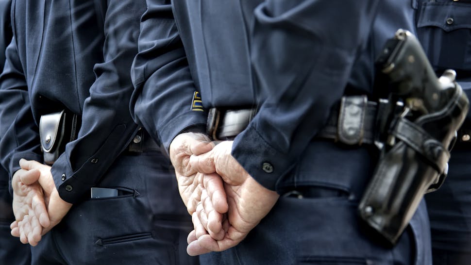 Cops Officers standing with hands behind - stock photo