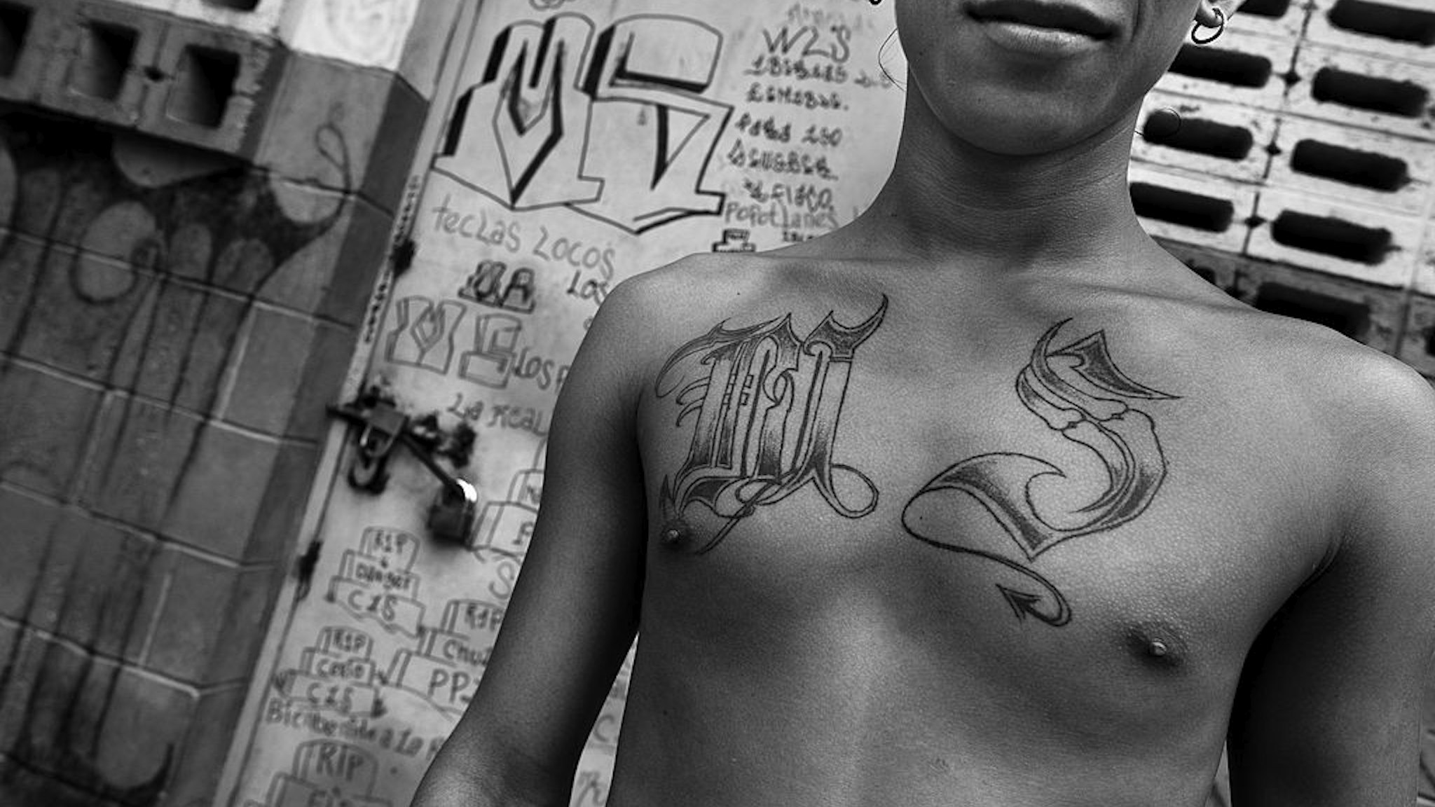 A member of the Mara Salvatrucha gang (MS-13) shows off his gang tattoos in the prison of Tonacatepeque, on 18 May 2011 in Tonacatepeque, El Salvador.