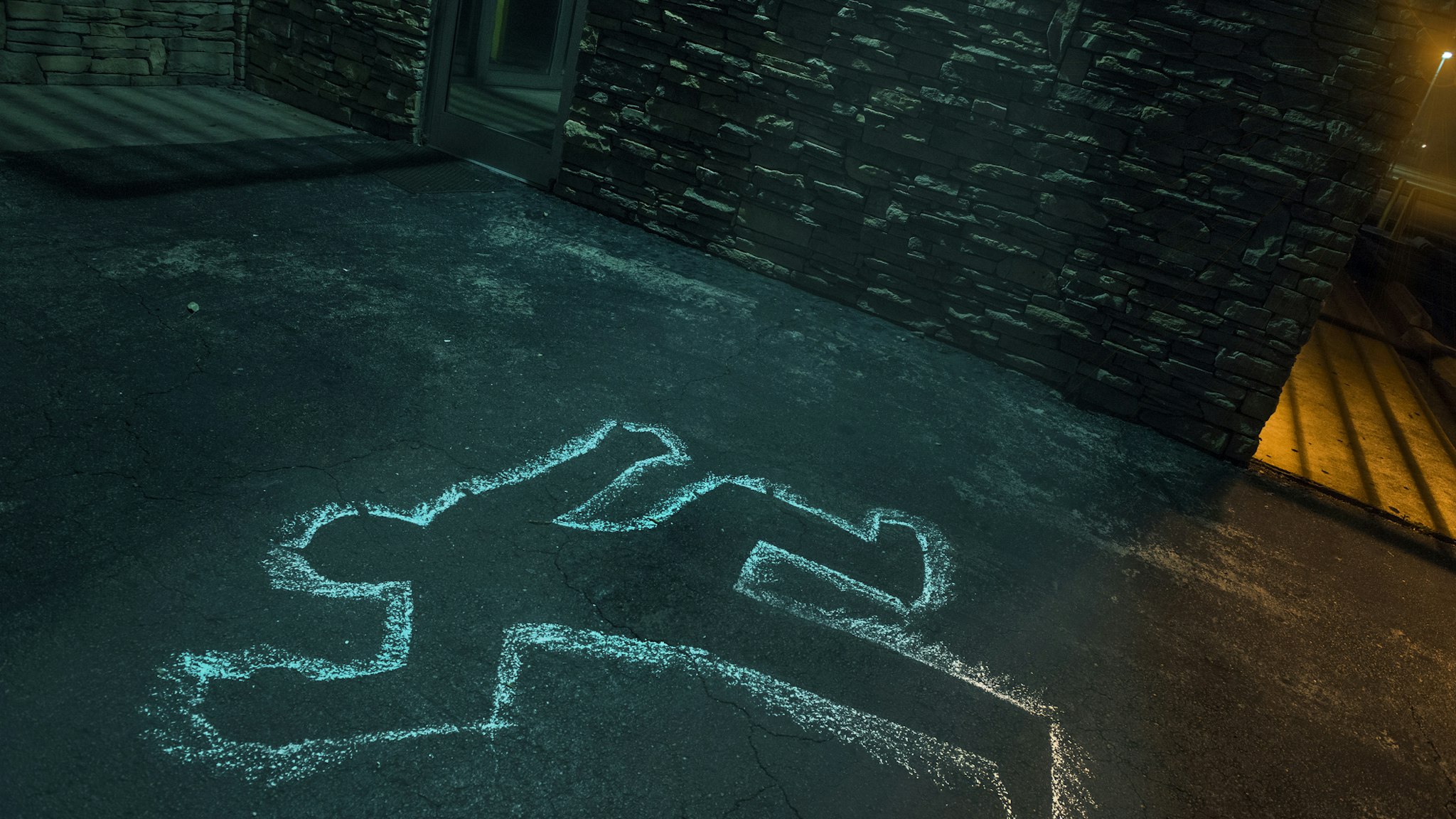 Chalk outline of body of victim on pavement - stock photo