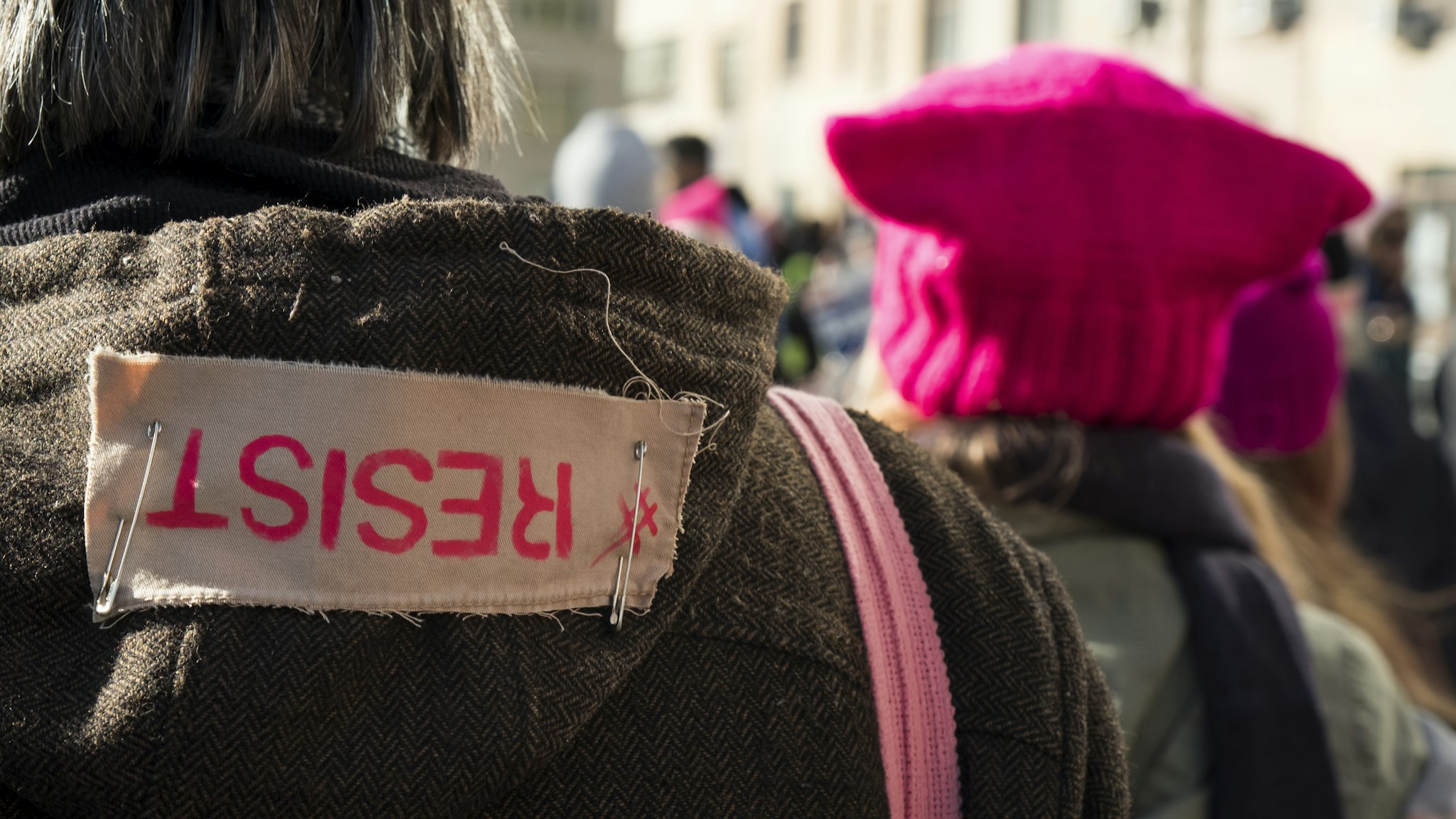 NEW YORK, NY - JANUARY 20: A demonstrator has a safety pin patch saying "RESIST" during the second annual Women's March in the borough of Manhattan in New York City, U.S. on Saturday, January 20, 2018. One year after the inauguration of President Donald Trump, thousands of people will again gather to protest for equal rights at the 2018 Women's March. (Photo by Ira L. Black/Corbis via Getty Images)