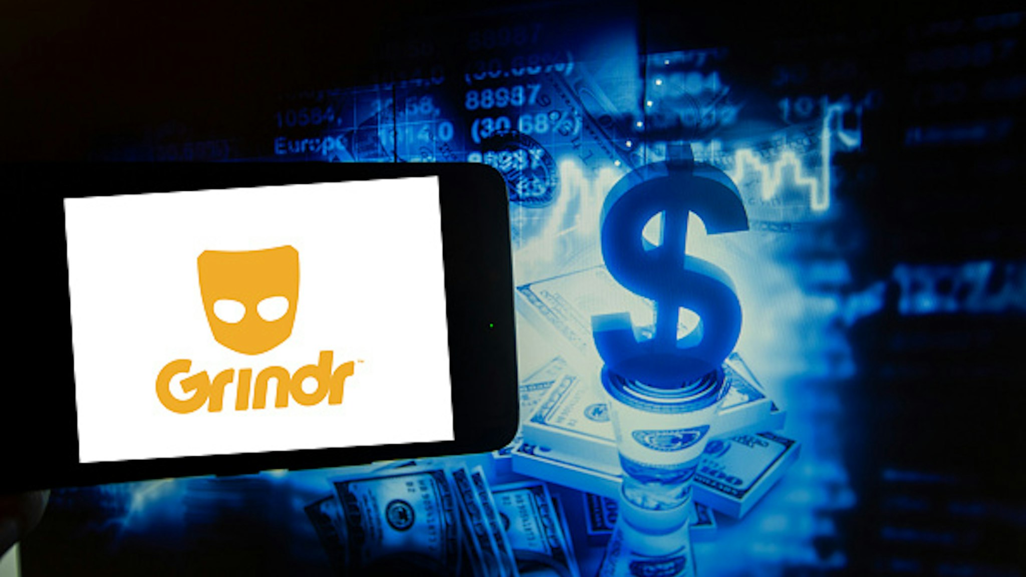In this photo illustration taken in New York, US, on 15 October 2019 show the logo of the gay dating app Grindr is seen on a screen next to an illustration of big money, stock market and business. Hundreds of millions are using dating apps.