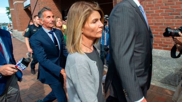 Actress Lori Loughlin (C) and husband Mossimo Giannulli (2nd L) exit the Boston Federal Court house after a pre-trial hearing with Magistrate Judge Kelley at the John Joseph Moakley US Courthouse in Boston on August 27, 2019. - Loughlin and Giannulli are charged with conspiracy to commit mail and wire fraud and conspiracy to commit money laundering in the college admissions scandal. (Photo by Joseph Prezioso / AFP) (Photo credit should rea