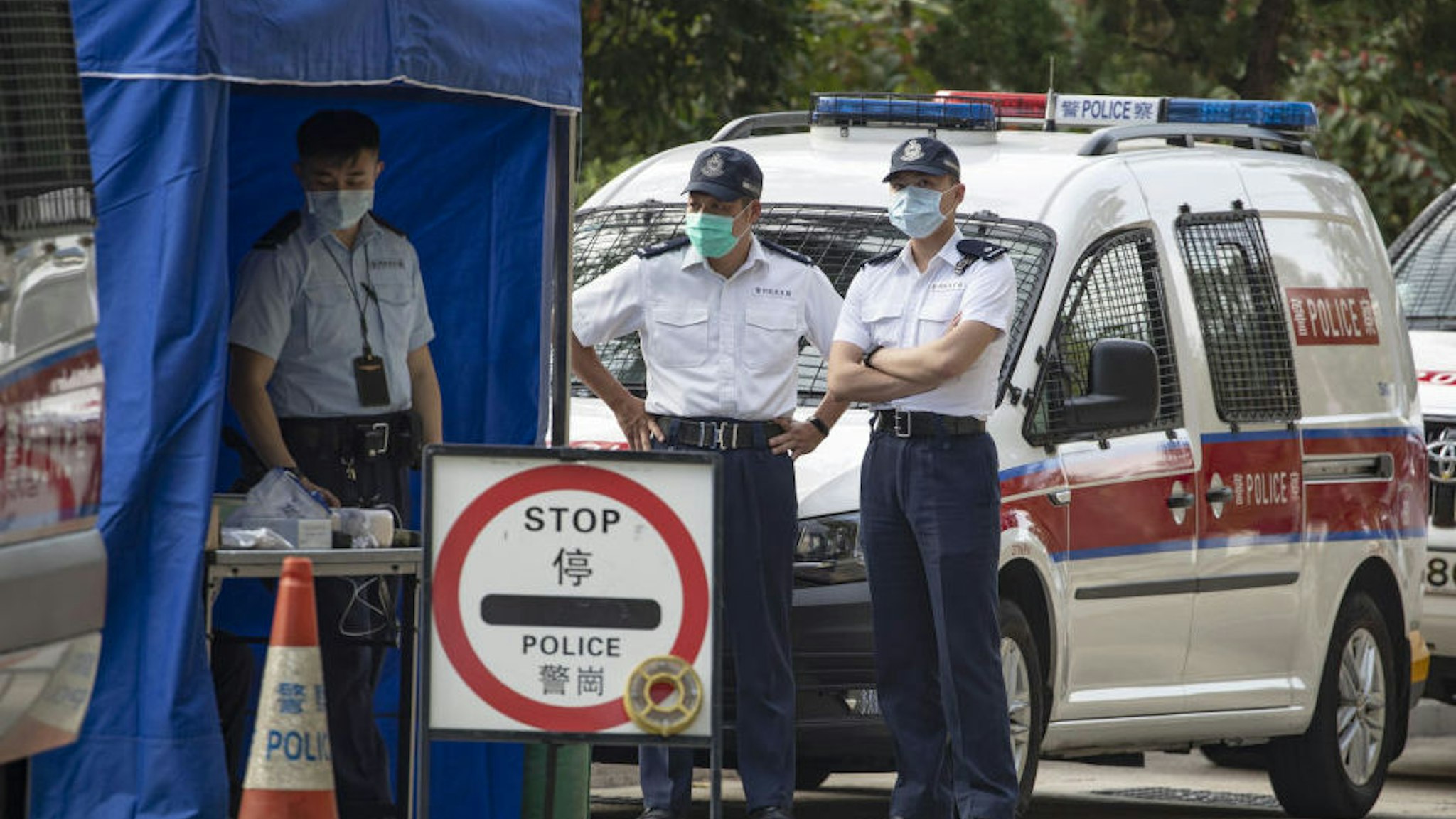 Police officers wearing face masks stand guard at a road block outside the Lady MacLehose Holiday Village, a temporary quarantine camp, in Hong Kong, China, on Thursday, Jan. 23, 2020. A deadly coronavirus, which first appeared last month in the city of Wuhan in central China, has spread from the mainland to locations from Hong Kong to the U.S., coloring what is usually a period of celebration and reunion for Chinese people across the world with tension and anxiety.