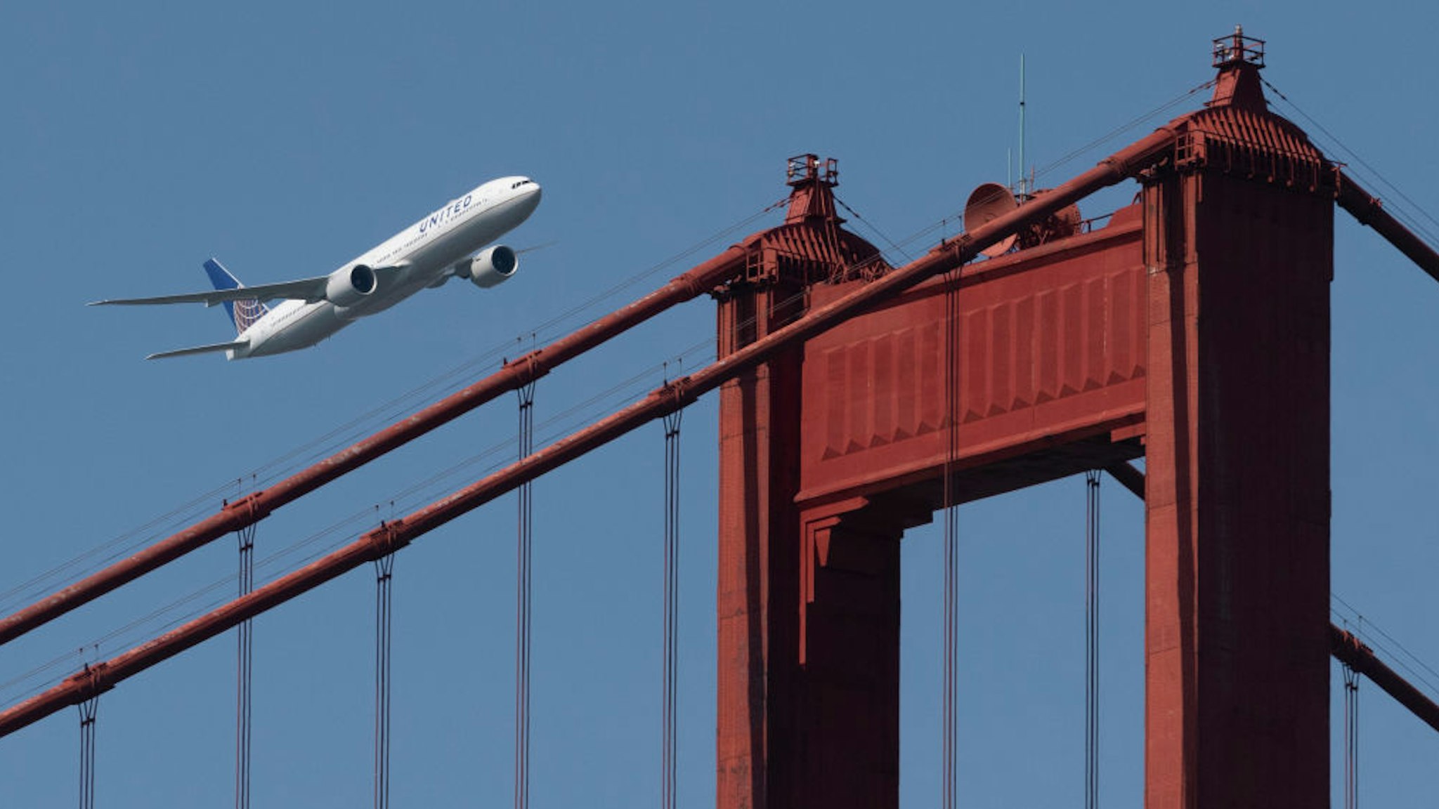 A United Airlines Boeing 777-300ER flies over the Golden Gate Bridge during Fleet Week 2019 in San Francisco, California on October 11, 2019. United Airlines will hold a conference call to discuss third-quarter 2019 financial results on Wednesday, October 16. (Photo by Yichuan Cao/NurPhoto)