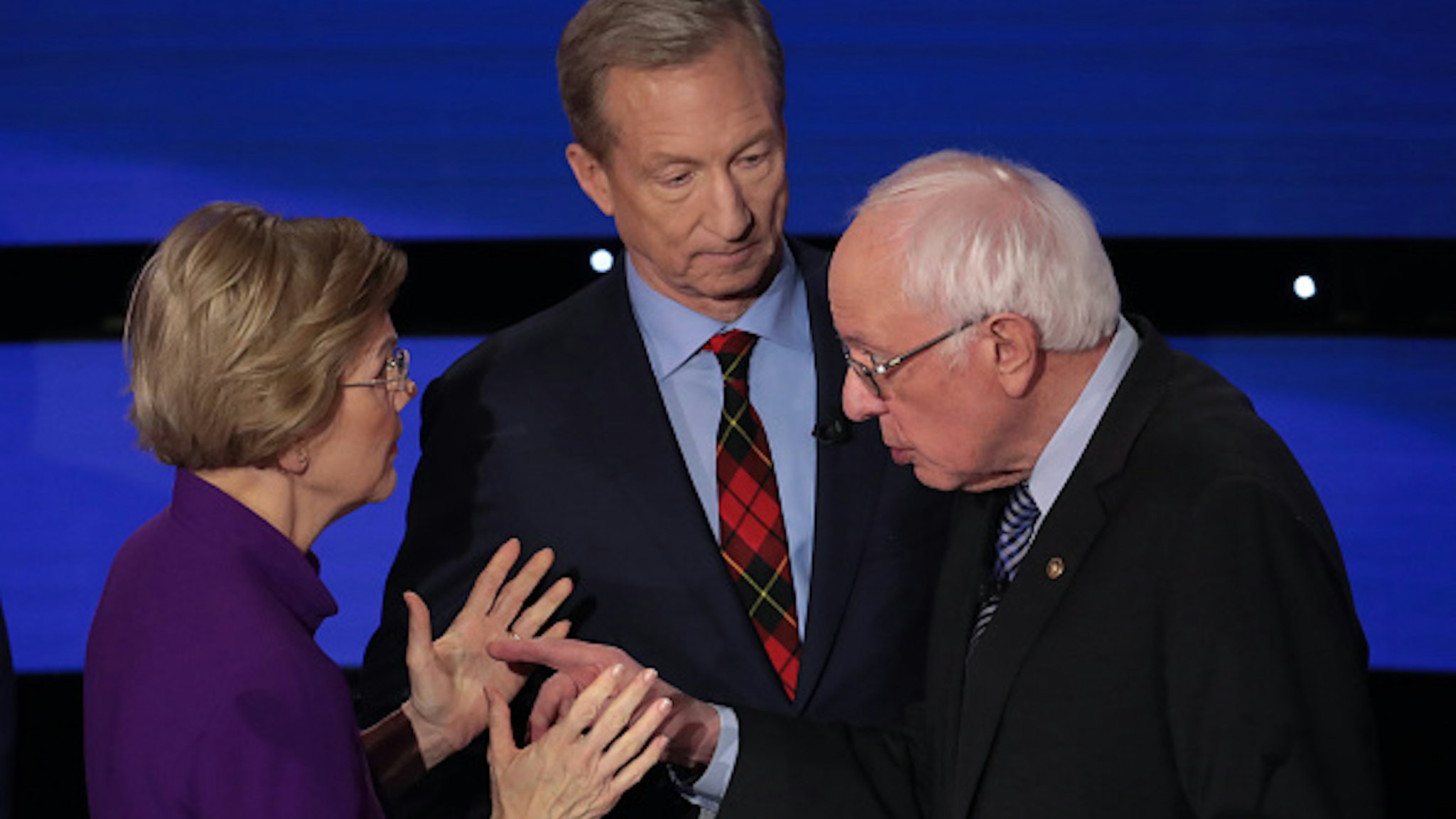 DES MOINES, IOWA - JANUARY 14: Sen. Elizabeth Warren (D-MA) and Sen. Bernie Sanders (I-VT) speak as Tom Steyer looks on after the Democratic presidential primary debate at Drake University on January 14, 2020 in Des Moines, Iowa. Six candidates out of the field qualified for the first Democratic presidential primary debate of 2020, hosted by CNN and the Des Moines Register.