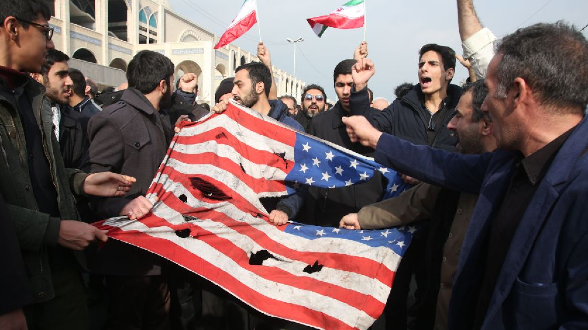 Iranians tear up a US flag during a demonstration in Tehran on January 3, 2020 following the killing of Iranian Revolutionary Guards Major General Qasem Soleimani in a US strike on his convoy at Baghdad international airport.