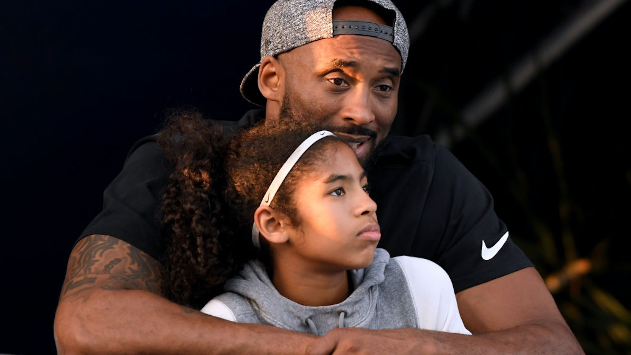 Kobe Bryant and daughter Gianna Bryant watch during day 2 of the Phillips 66 National Swimming Championships at the Woollett Aquatics Center on July 26, 2018 in Irvine, California.