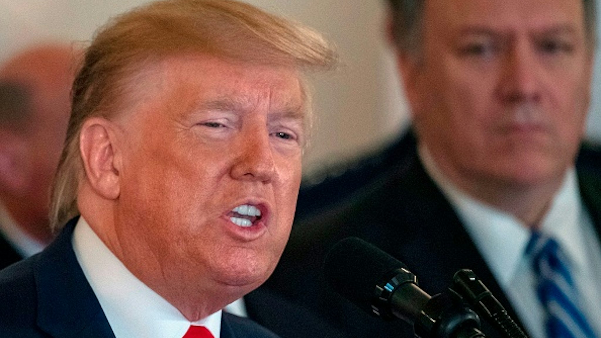 US Secretary of State Mike Pompeo(R) listens as US President Donald Trump speaks about the situation with Iran in the Grand Foyer of the White House in Washington, DC, January 8, 2020.