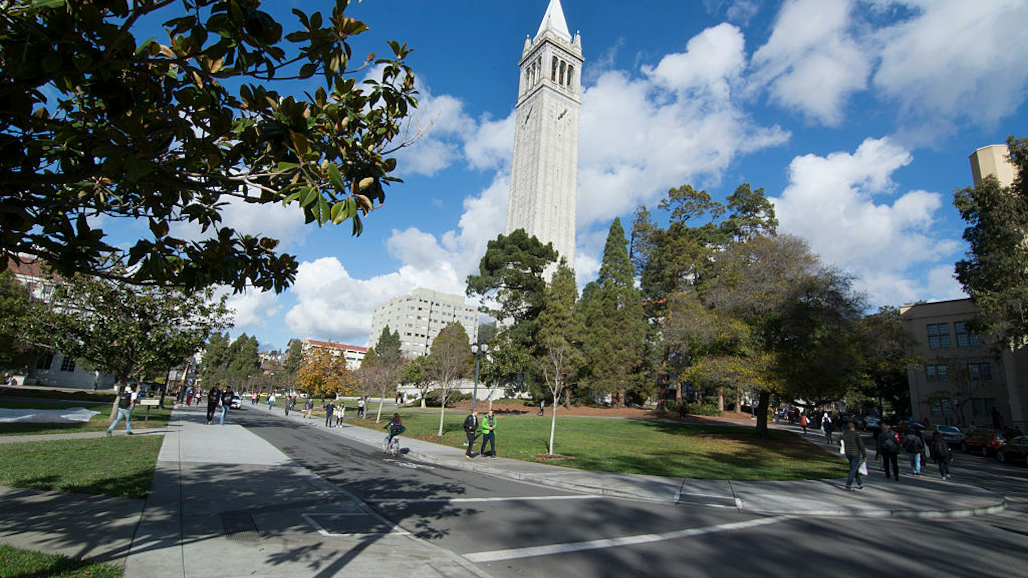 Berkeley California University of California at Berkeley, students with Sather Tower or Campanile tower in background with clouds and color.