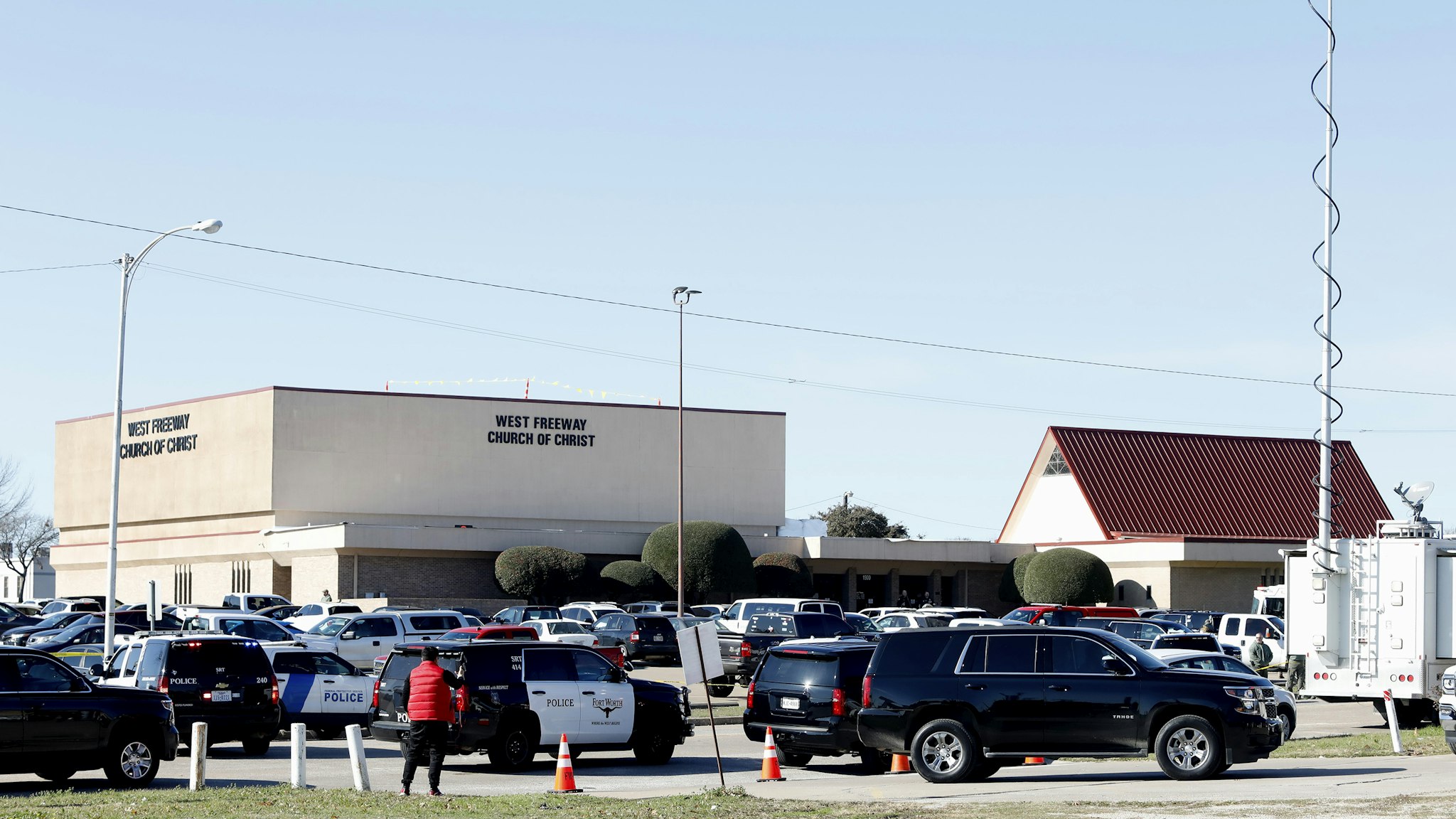 WHITE SETTLEMENT, TX - DECEMBER 29: Law enforcement and the media work outside the West Freeway Church of Christ after a shooting took place during services on December 29, 2019 in White Settlement, Texas. The gunman was killed by armed members of the church after he opened fire during Sunday services. According to reports, a security guard was killed by the assailant and one other person has life-threatening injuries.