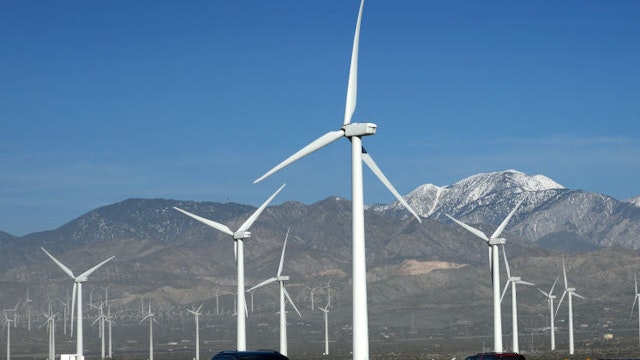 PALM SPRINGS, CALIFORNIA - FEBRUARY 27, 2019: Automobiles travel along Interstate 10 as wind turbines generate electricity at the San Gorgonio Pass Wind Farm near Palm Springs, California. Located in the windy gap between Southern California's two highest mountains, the facility is one of three major wind farms in California.