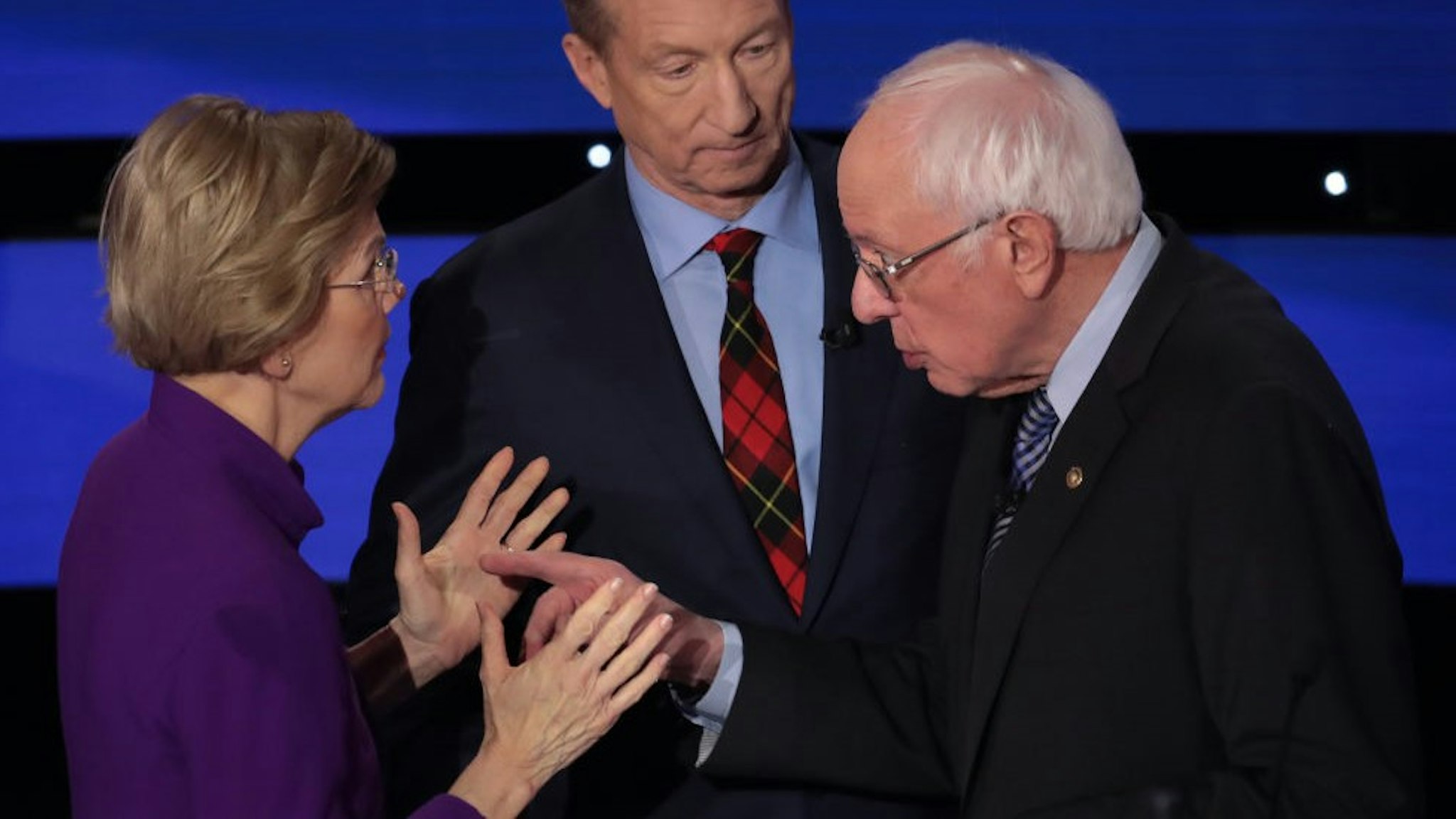 DES MOINES, IOWA - JANUARY 14: Sen. Elizabeth Warren (D-MA) and Sen. Bernie Sanders (I-VT) speak as Tom Steyer looks on after the Democratic presidential primary debate at Drake University on January 14, 2020 in Des Moines, Iowa. Six candidates out of the field qualified for the first Democratic presidential primary debate of 2020, hosted by CNN and the Des Moines Register. (Photo by