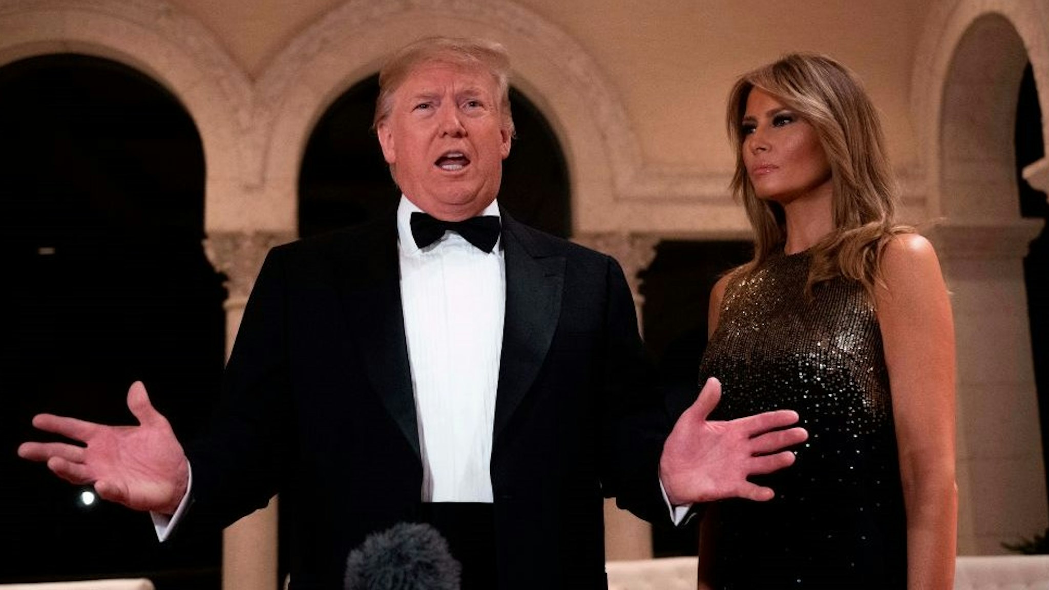 US President Donald Trump and First Lady Melania Trump speak to the press outside the grand ballroom as they arrive for a New Year's celebration at Mar-a-Lago in Palm Beach, Florida, on December 31, 2019. (Photo by JIM WATSON / AFP) (Photo by
