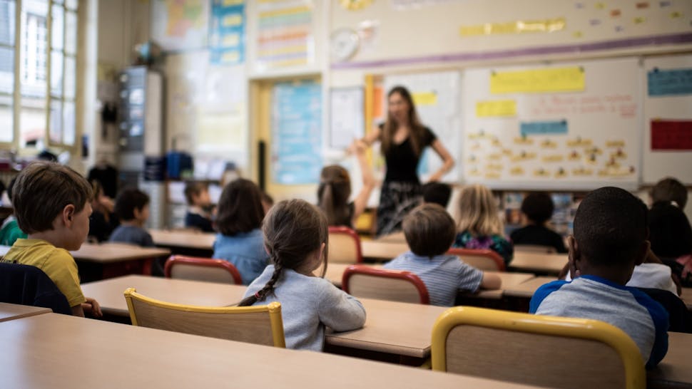 Classroom Children listen to their teacher as they sit in a classroom on the first day of the start of the school year, at the Chaptal elementary school in Paris, on September 2, 2019.