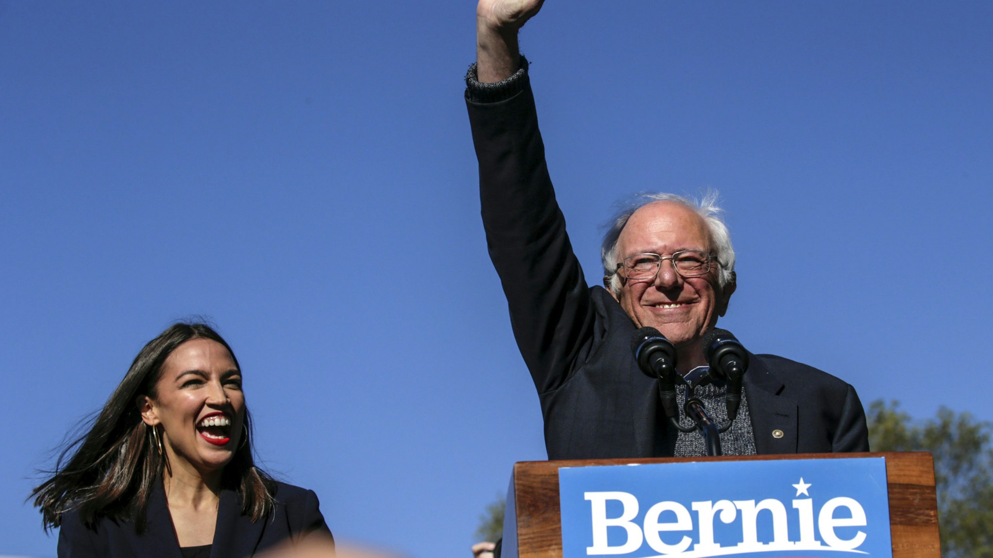 NEW YORK, NY - OCTOBER 19: Democratic presidential candidate, Sen. Bernie Sanders (I-VT) waves with Rep. Alexandria Ocasio-Cortez (D-NY) as she endorses him during his speech at a campaign rally in Queensbridge Park on October 19, 2019 in the Queens borough of New York City. This is Sanders' first rally since he paused his campaign for the nomination due to health problems.