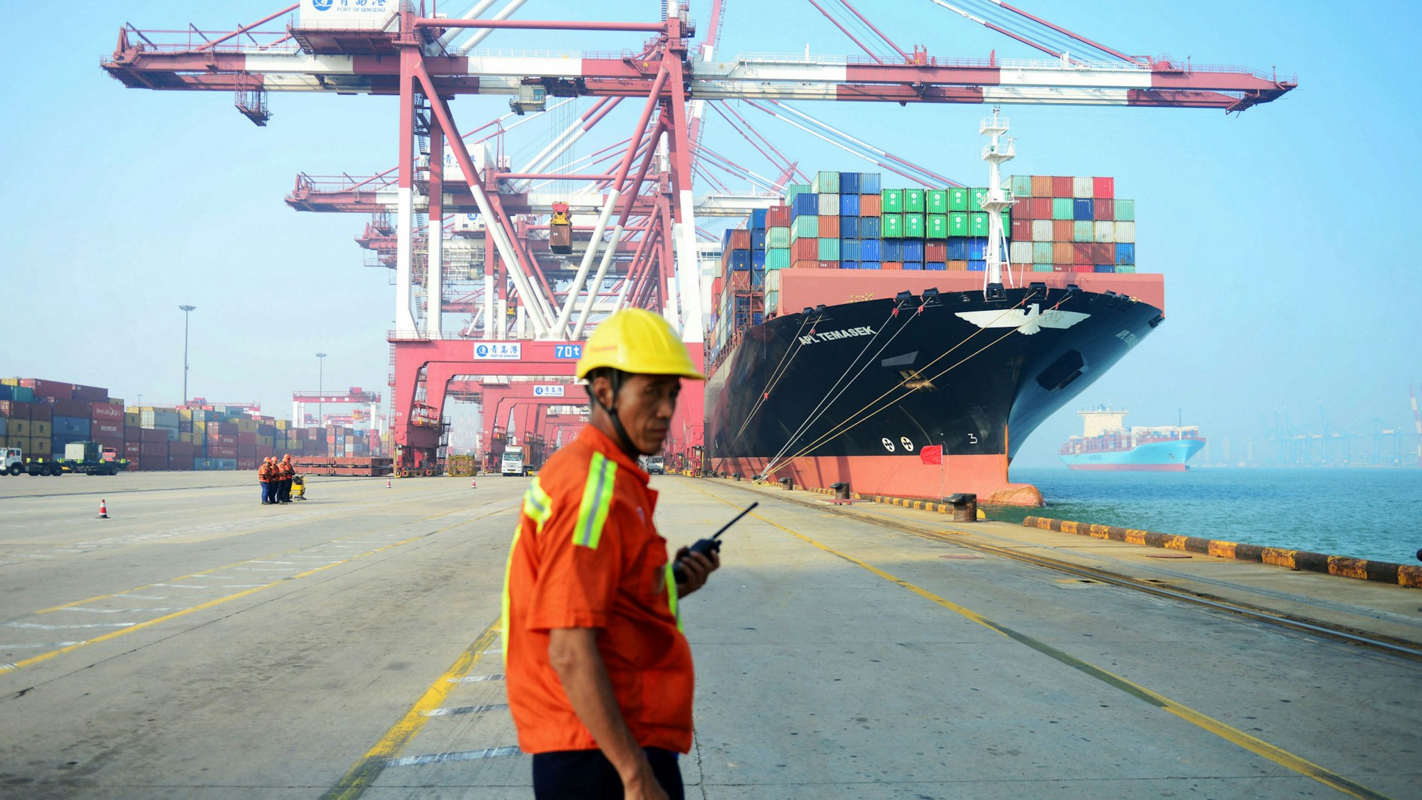 A Chinese worker looks on as a cargo ship is loaded at a port in Qingdao, eastern China's Shandong province on July 13, 2017. China's exports rose a forecast-beating 11.3 percent on-year in June, data showed July 13, fuelling hopes of stability in the world's second-largest economy.
