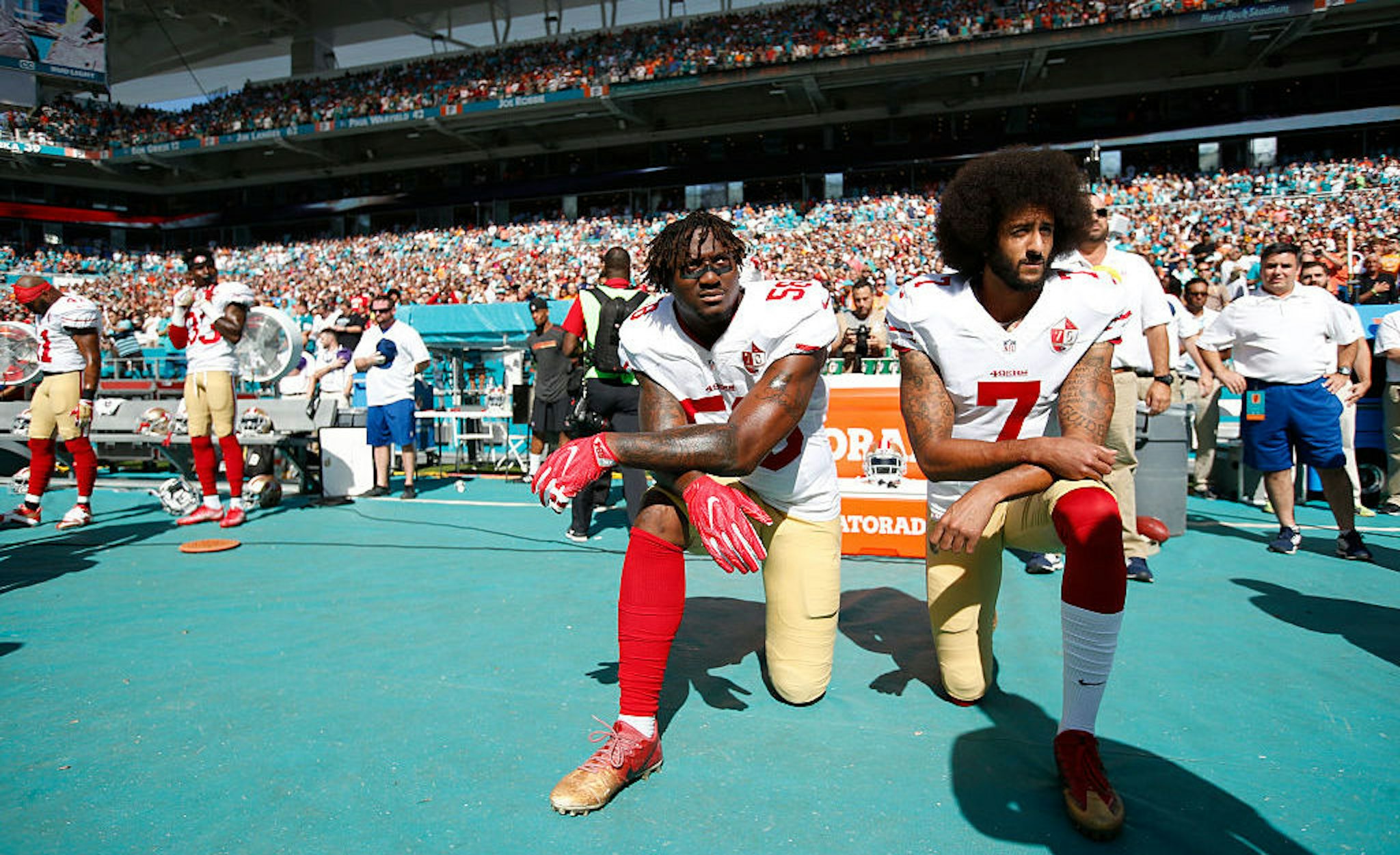 Eli Harold #58 and Colin Kaepernick #7 of the San Francisco 49ers kneel on the sideline, during the anthem, prior to the game against the Miami Dolphins at Hard Rock Stadium on November 27, 2016 in Miami Gardens, Florida. The Dolphins defeated the 49ers 31-24. (Photo by Michael Zagaris/San Francisco 49ers/Getty Images)