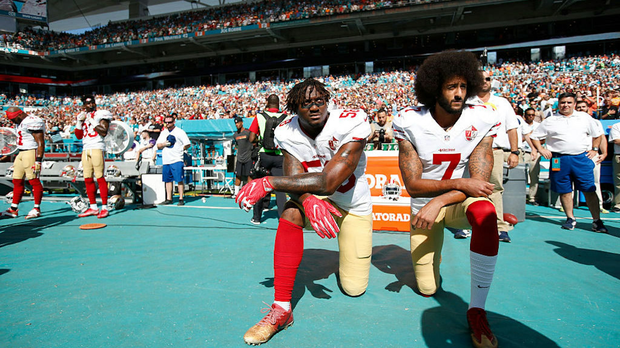 Eli Harold #58 and Colin Kaepernick #7 of the San Francisco 49ers kneel on the sideline, during the anthem, prior to the game against the Miami Dolphins at Hard Rock Stadium on November 27, 2016 in Miami Gardens, Florida. The Dolphins defeated the 49ers 31-24. (Photo by Michael Zagaris/San Francisco 49ers/Getty Images)