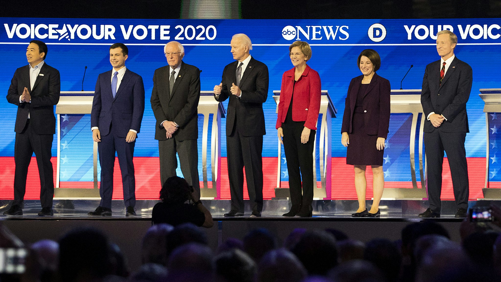 2020 Democratic presidential candidates, from left, Andrew Yang, founder of Venture for America, Pete Buttigieg, former mayor of South Bend, Senator Bernie Sanders, an Independent from Vermont, Former Vice President Joe Biden, Senator Elizabeth Warren, a Democrat from Massachusetts, Senator Amy Klobuchar, a Democrat from Minnesota, and Tom Steyer, co-founder of NextGen Climate Action Committee, arrive on stage during the Democratic presidential debate at Saint Anselm College in Manchester, New Hampshire, U.S., on Friday, Feb. 7, 2020. The New Hampshire debates often mark a turning point in a presidential campaign, as the field of candidates is winnowed and voters begin to pay closer attention.