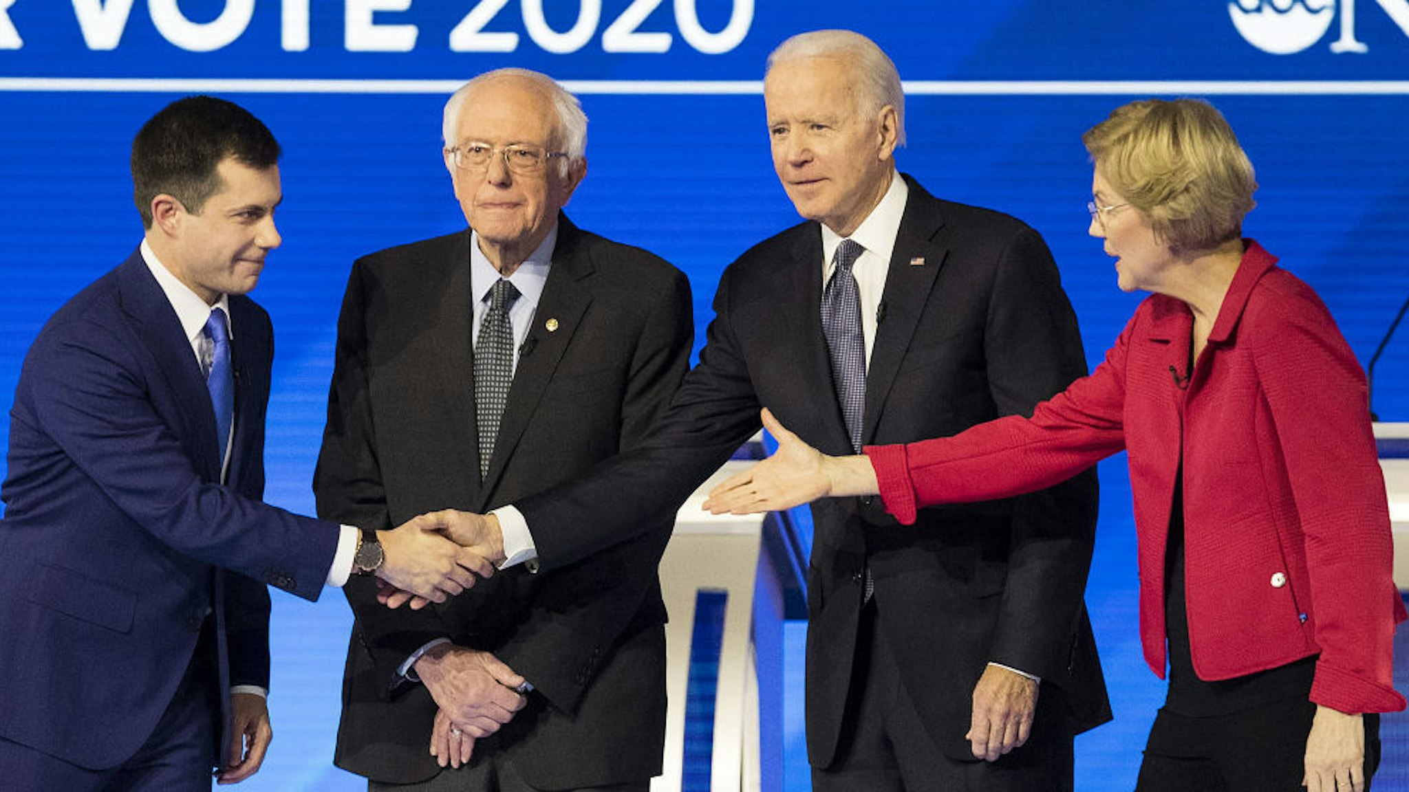Pete Buttigieg, former mayor of South Bend and 2020 presidential candidate, left, shakes hands with Former Vice President Joe Biden, as Senator Bernie Sanders, an Independent from Vermont, second left, and Senator Elizabeth Warren, a Democrat from Massachusetts, right, stand on stage ahead of the Democratic presidential debate at Saint Anselm College in Manchester, New Hampshire, U.S., on Friday, Feb. 7, 2020. The New Hampshire debates often mark a turning point in a presidential campaign, as the field of candidates is winnowed and voters begin to pay closer attention. Photographer: Adam Glanzman/Bloomberg