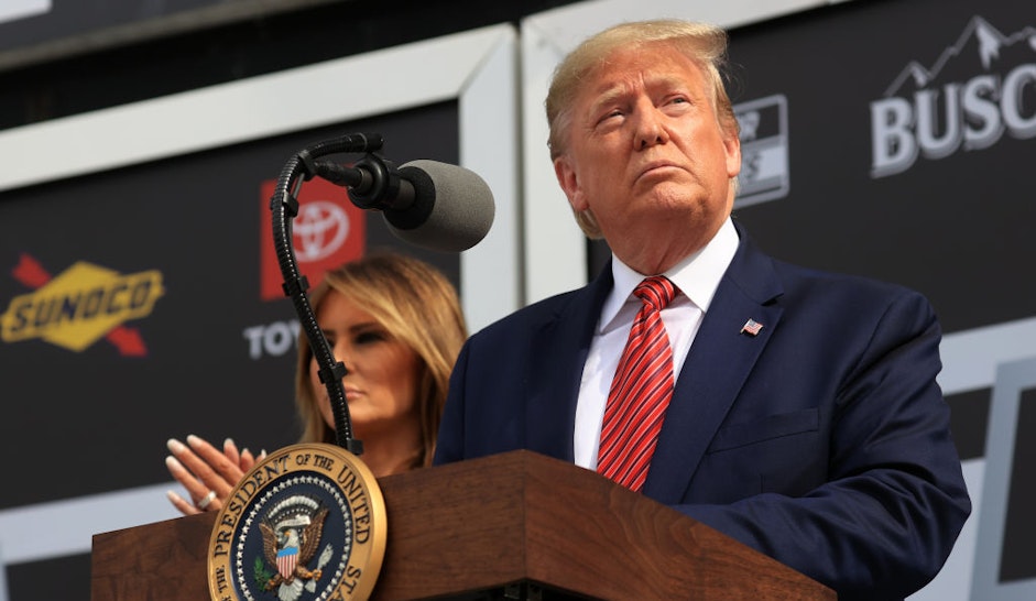 U.S. President Donald Trump speaks as First Lady Melania Trump looks on from Victory Lane prior to the NASCAR Cup Series 62nd Annual Daytona 500 at Daytona International Speedway on February 16, 2020 in Daytona Beach, Florida. (Photo by Chris Graythen/Getty Images)