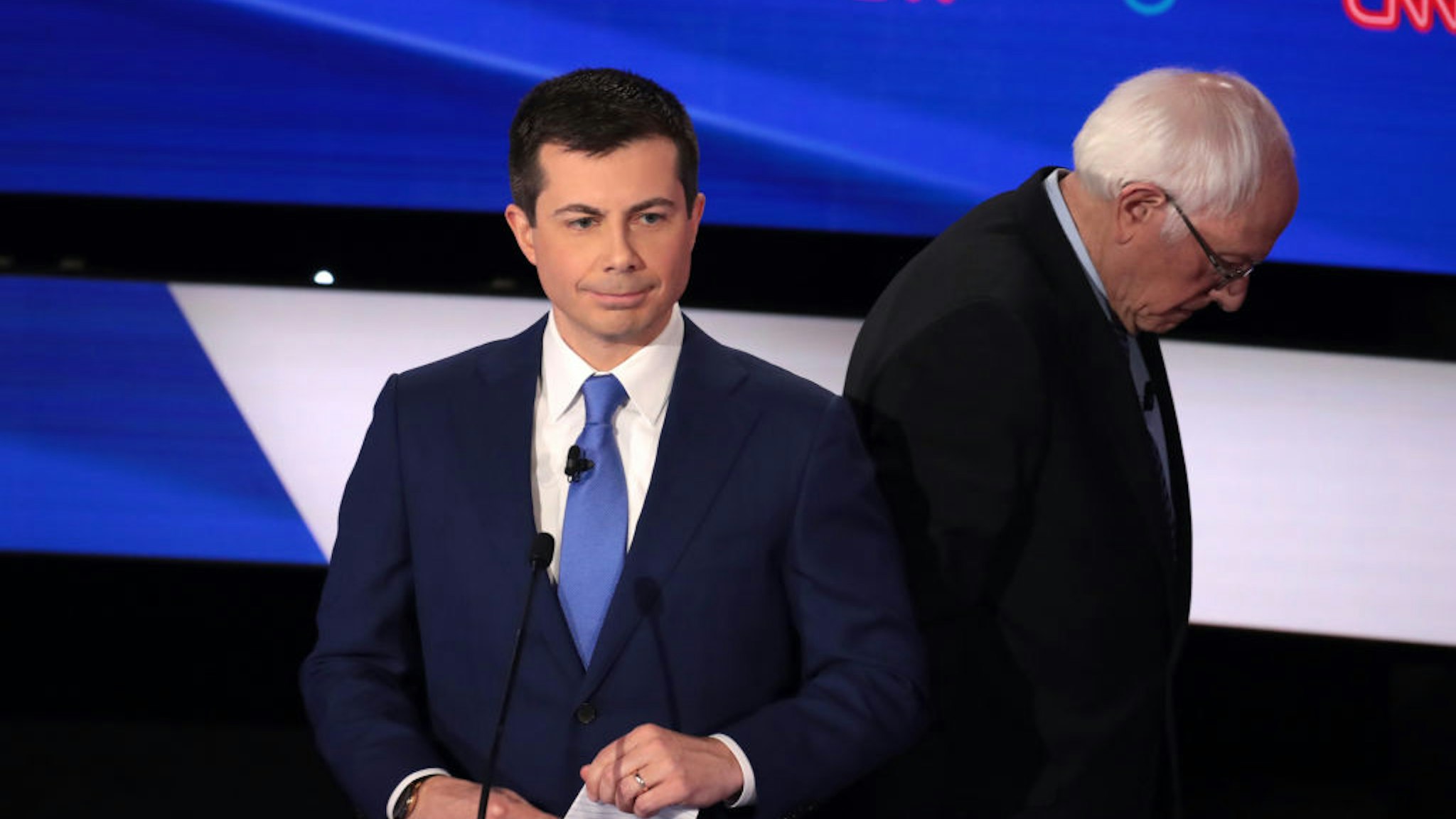 Former South Bend, Indiana Mayor Pete Buttigieg (C) and Sen. Bernie Sanders (I-VT) take a break during the Democratic presidential primary debate at Drake University on January 14, 2020 in Des Moines, Iowa.
