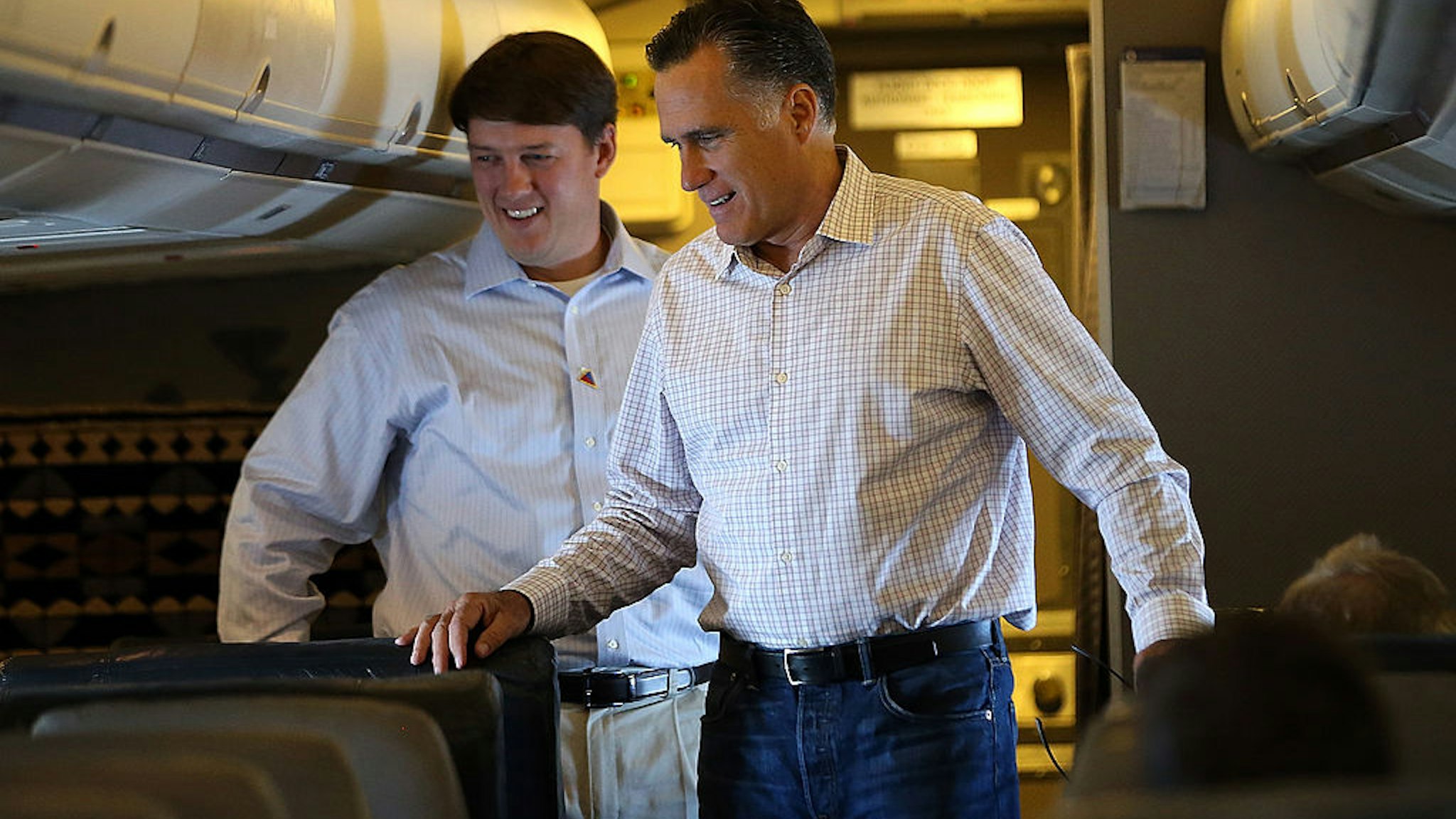 Republican presidential candidate, former Massachusetts Gov. Mitt Romney (R) stands with traveling press secretary Rick Gorka (L) aboard his campaign plane on August 29, 2012 en route to Indianapolis, Indiana.