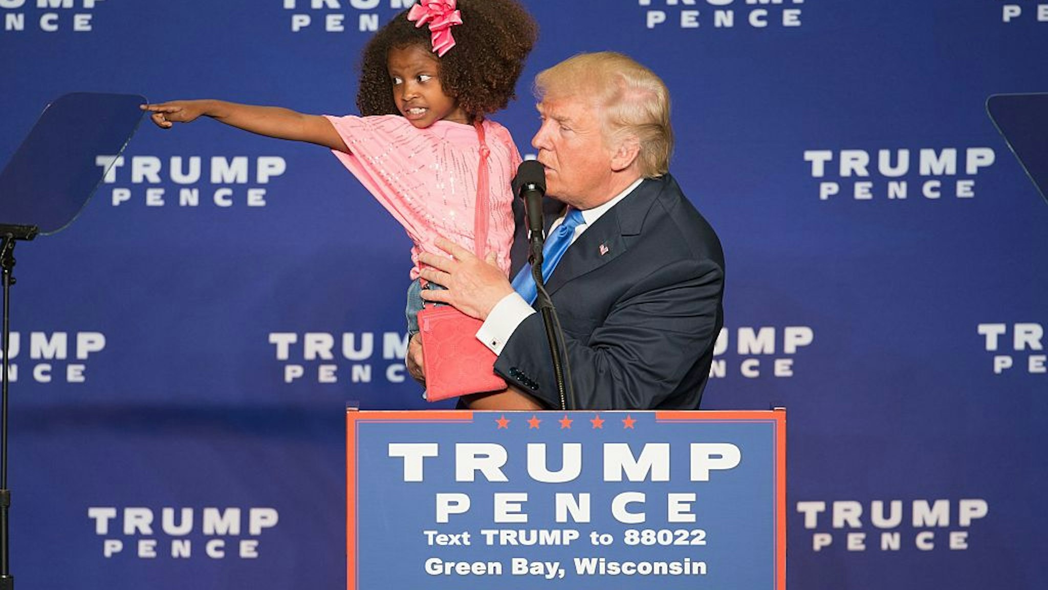 Republican presidential nominee Donald Trump holds a child as he speaks during a rally at the KI Convention Center on October 17, 2016 in Green Bay, Wisconsin.