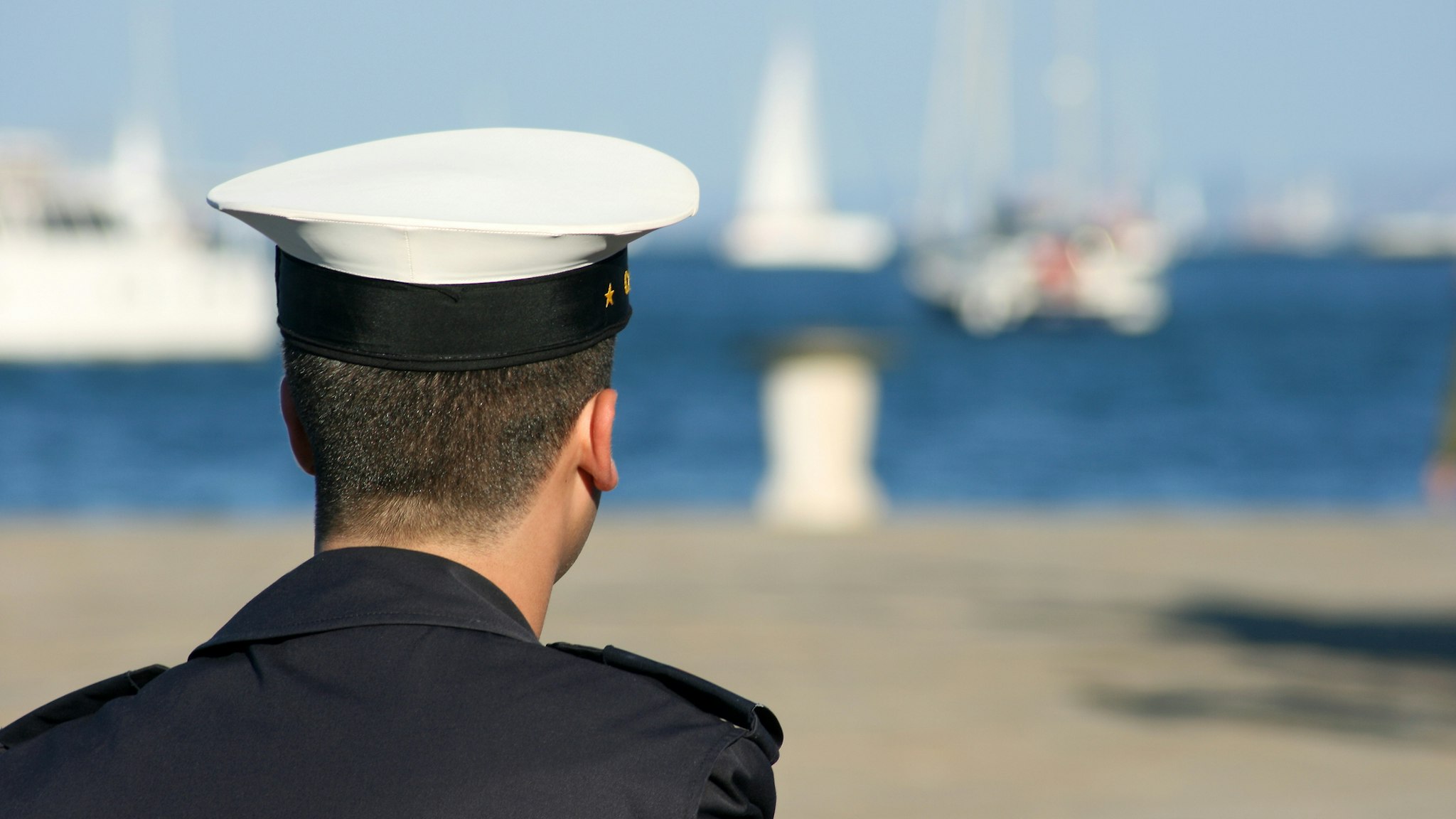 Young sailor in the harbor - stock photo