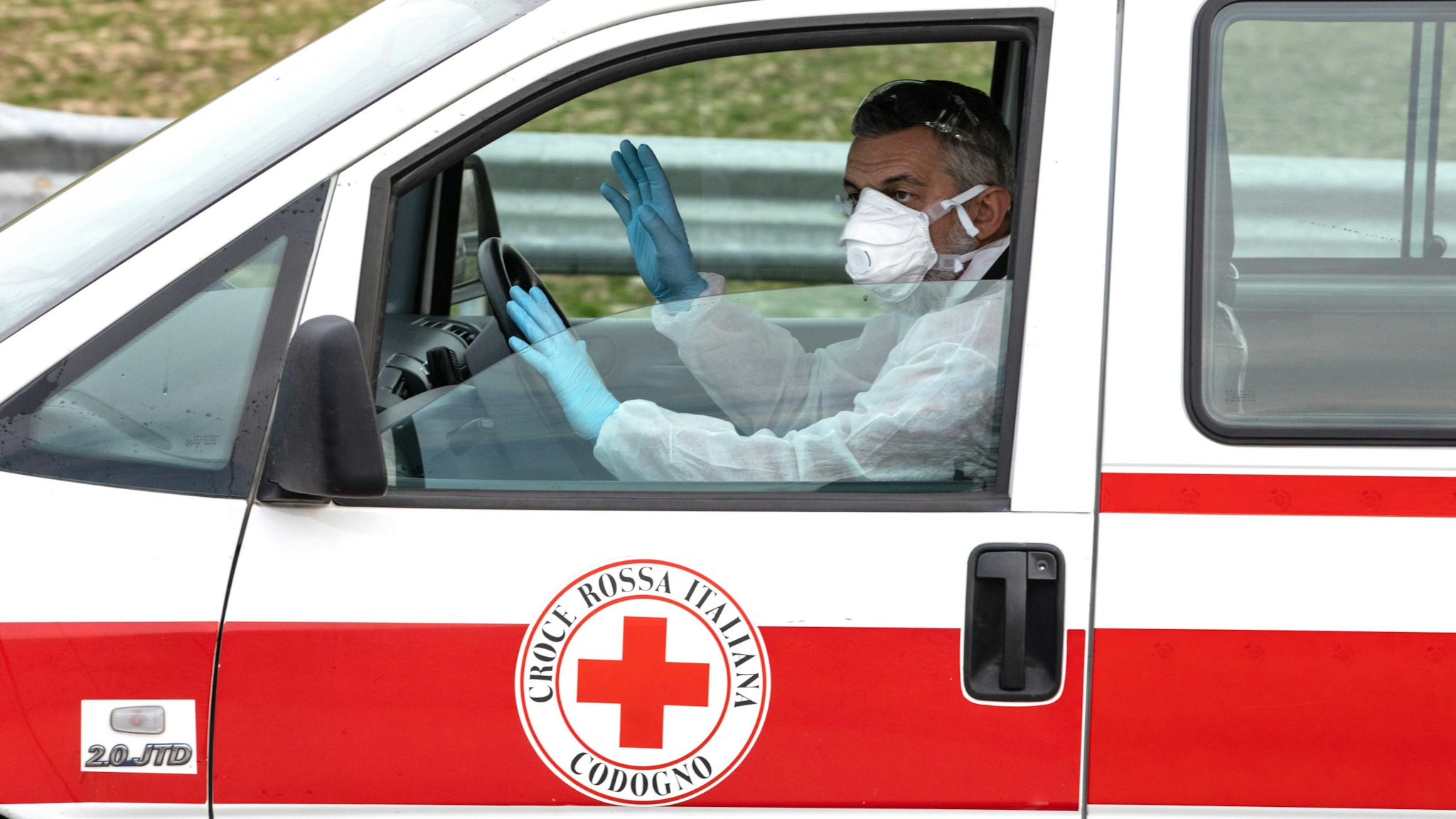 CASALPUSTERLENGO, ITALY - FEBRUARY 23: A member of the Italian Red Cross, wearing a respiratory mask, drives a vehicle on February 23, 2020 in Casalpusterlengo, south-west Milan, Italy. Casalpusterlengo is one of the ten small towns placed under lockdown earlier this morning as a second death from coronavirus sparked fears throughout the Lombardy region.